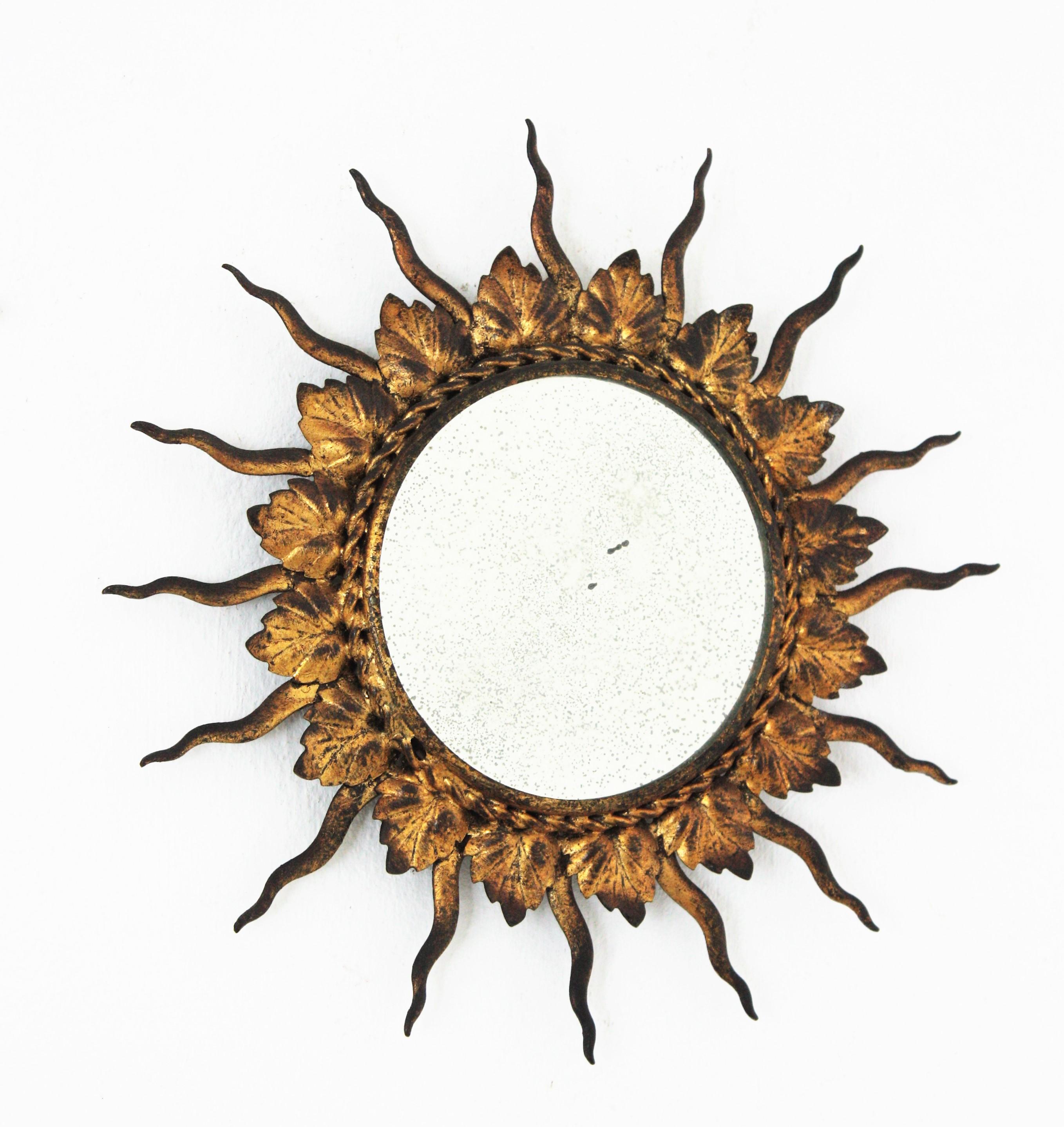 Mini sized sunburst mirror in gilt iron. France, 1960s
Lovely handcrafted gilt iron mini sunburst mirror. The frame is comprised by alternating iron leaves and rays finished with gold leaf gilding.
Unusual piece due to its small size.
Beautiful