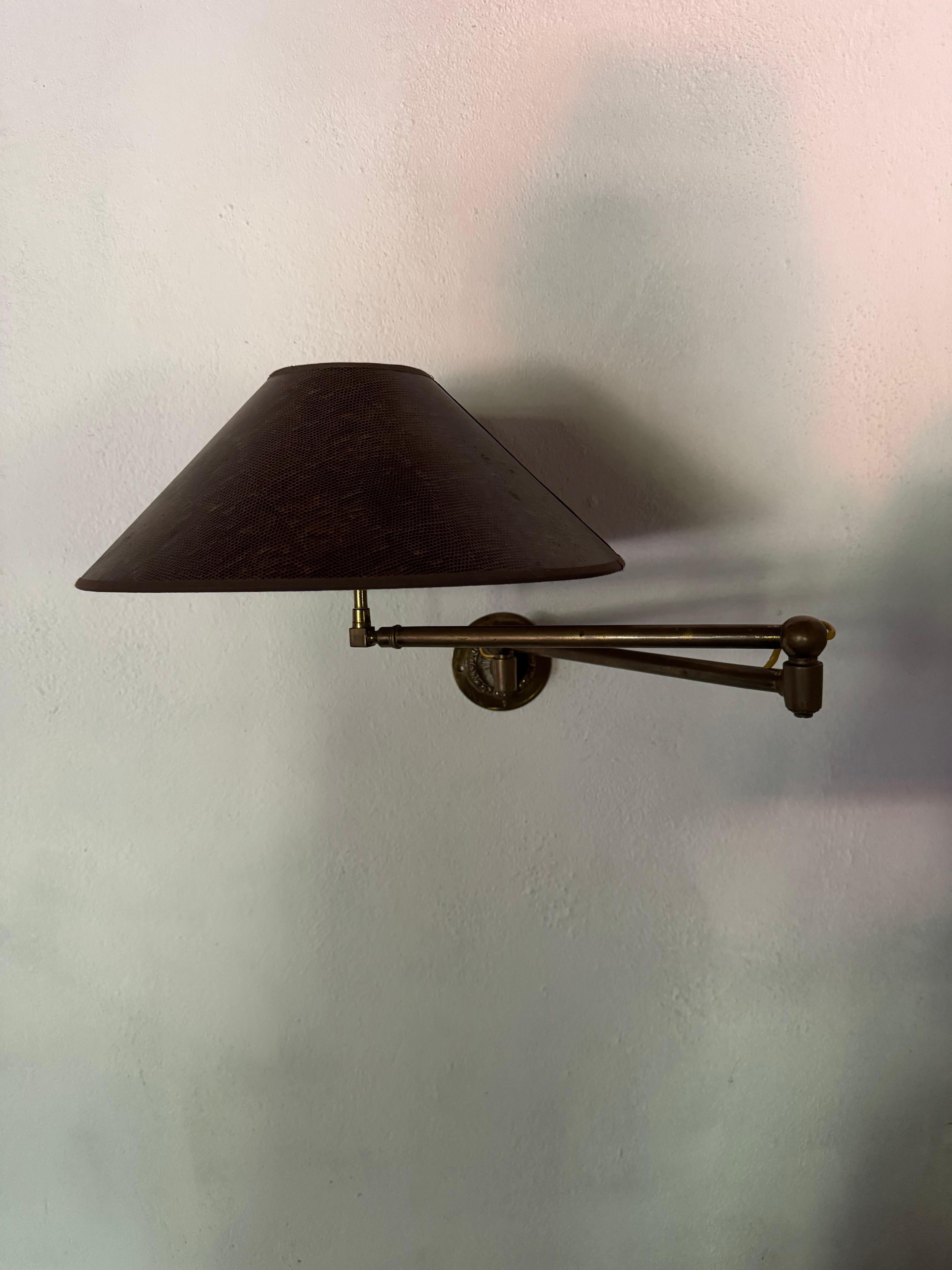 Une élégante applique à bras pivotant en bronze patiné avec une plaque de montage en fonte avec des détails de feuillage. Vendu recâblé. Abat-jour pour l'exposition. 