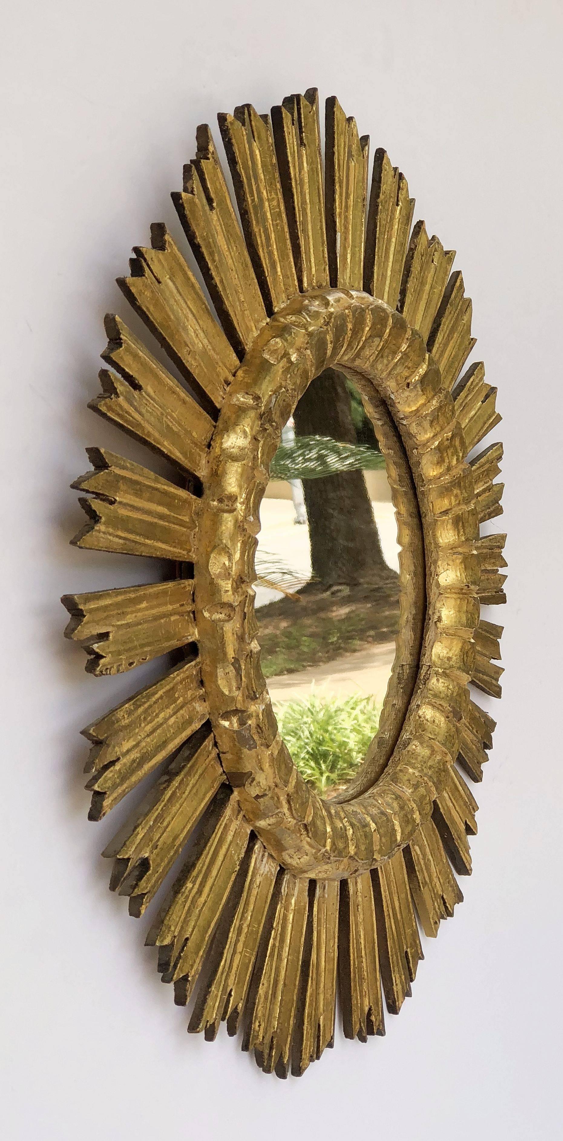A lovely French gilt sunburst (or starburst) mirror, 21 inches diameter, with round mirrored glass centre in moulded frame.