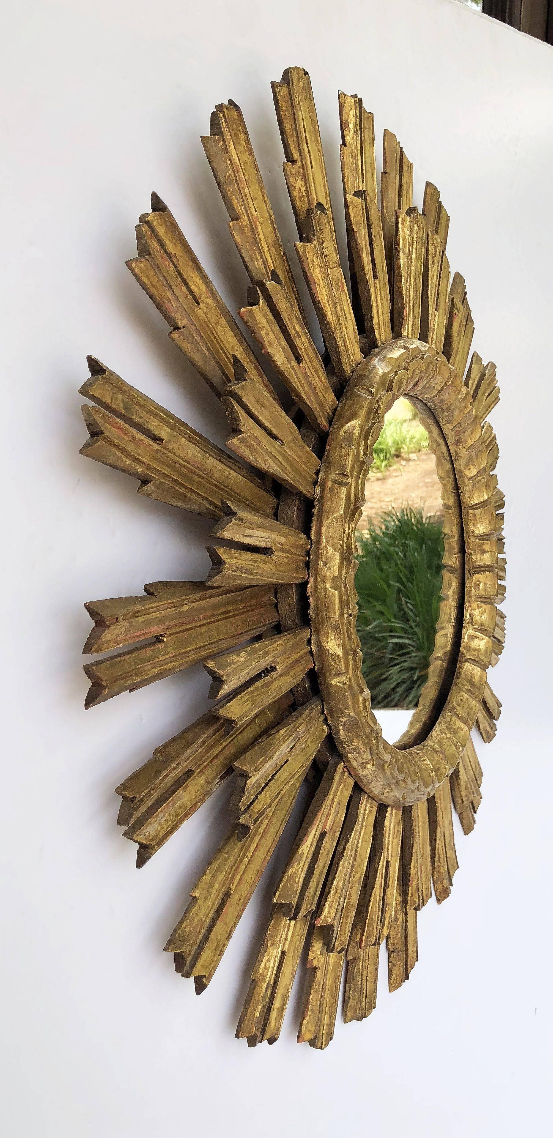 A lovely French gilt sunburst (or starburst) mirror, 25 inches diameter, with round mirrored glass centre in moulded frame.