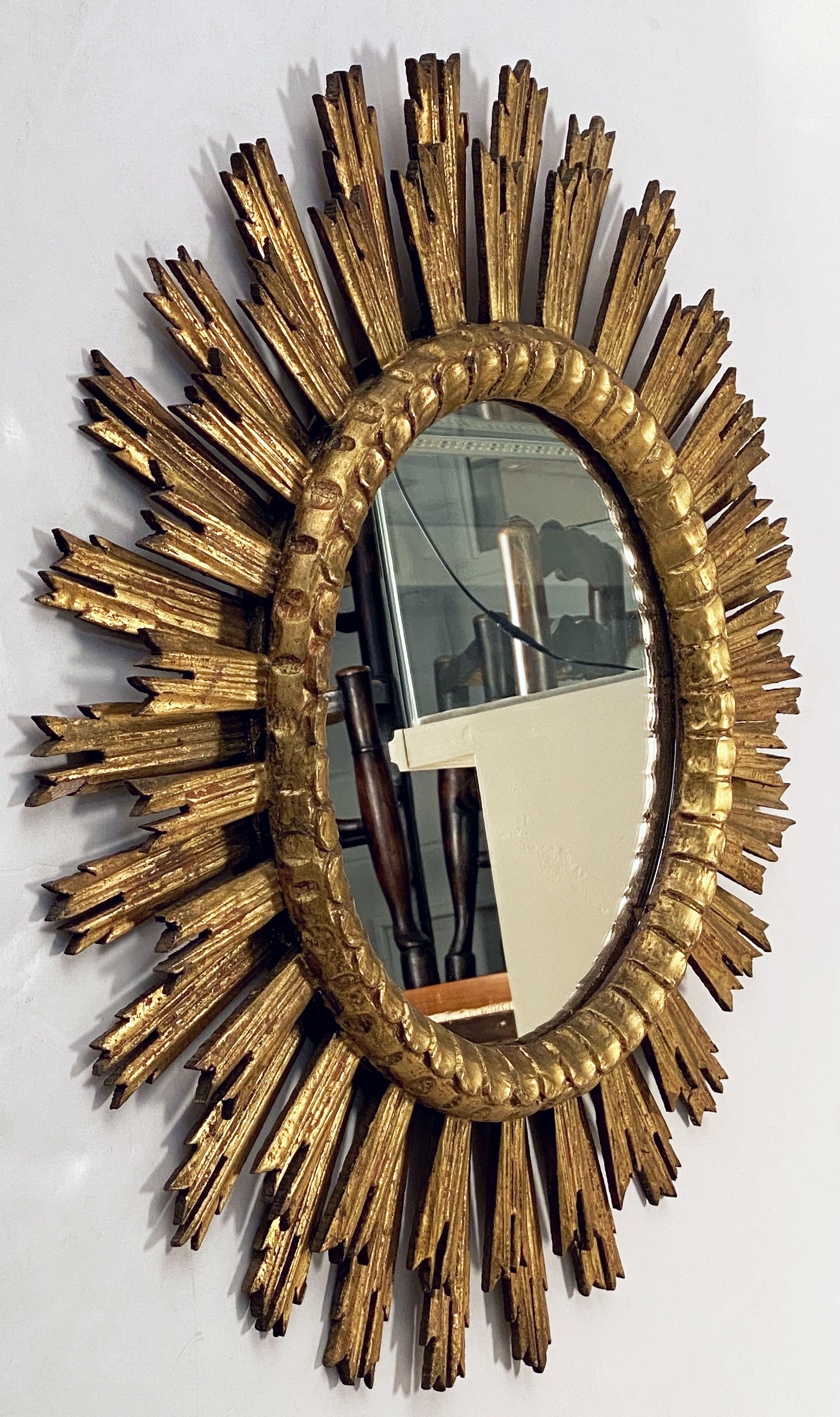 A lovely French gilt sunburst (or starburst) mirror, 30 inches diameter, with a round mirrored glass center in moulded frame.