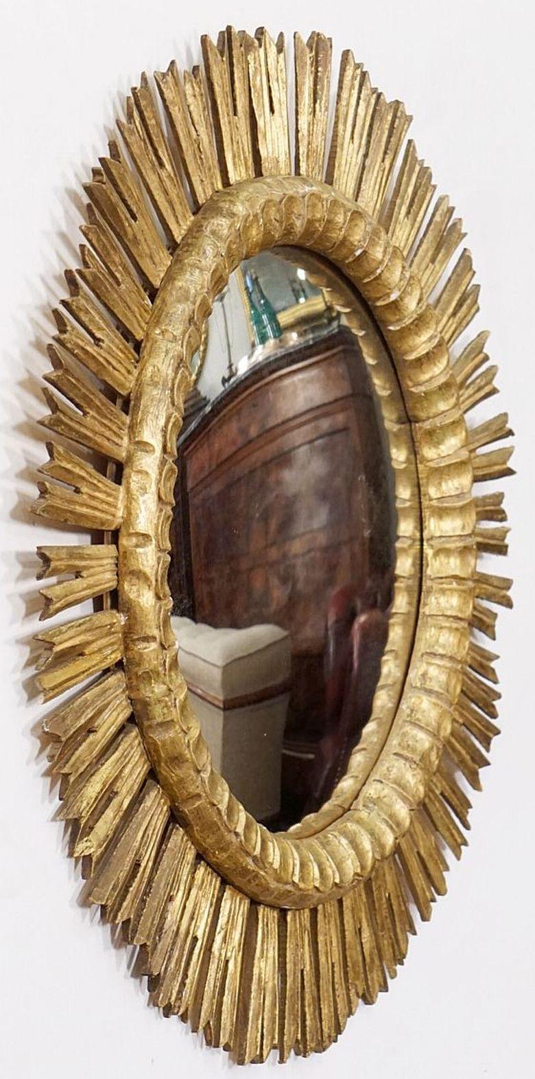A lovely large scale French gilt sunburst or starburst convex mirror, 25 inches diameter, with round mirrored convex glass center in a moulded frame surrounded by emanating gilded rays.

