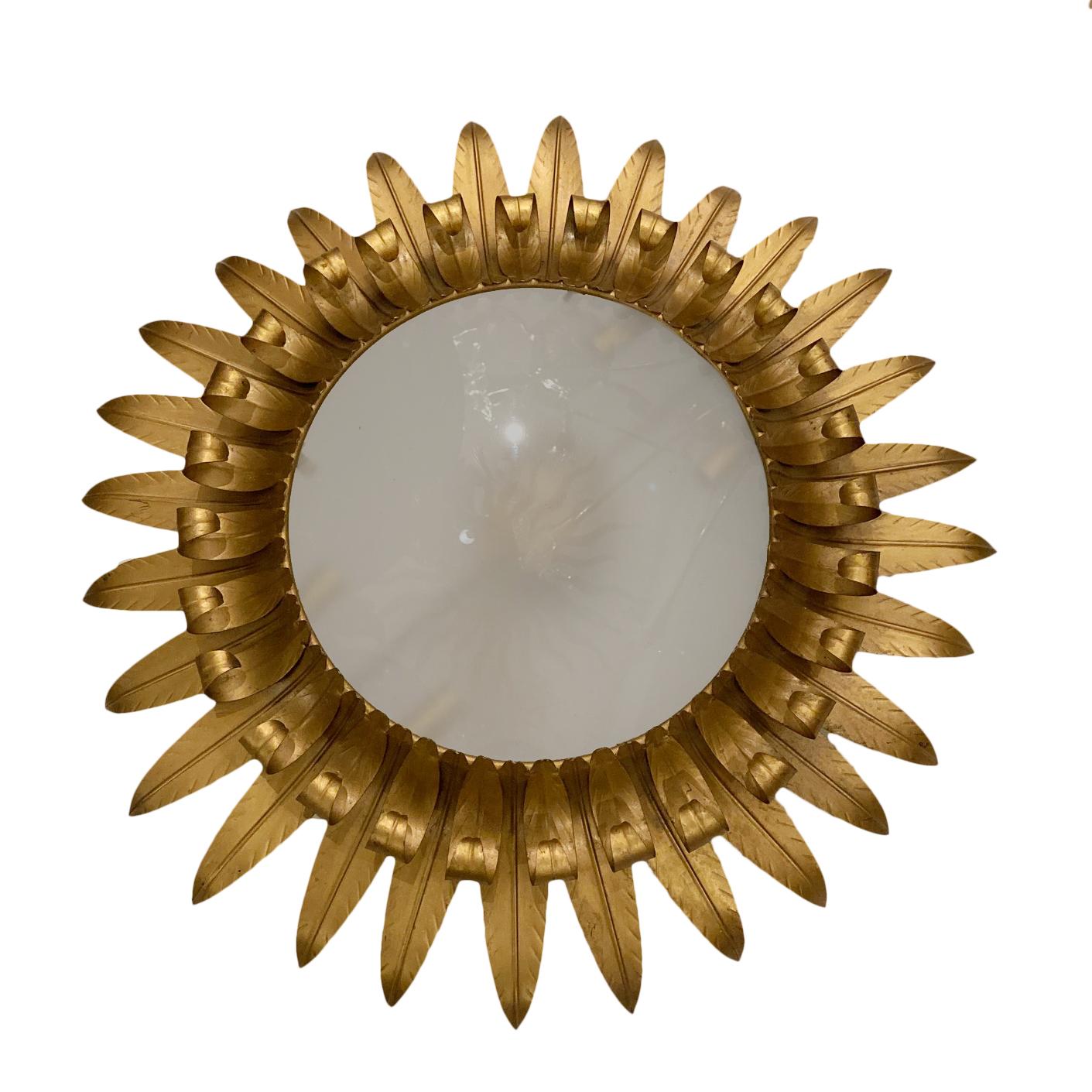 A circa 1950s French sunburst shaped light fixture with frosted glass inset.

Measurements:
Diameter 26