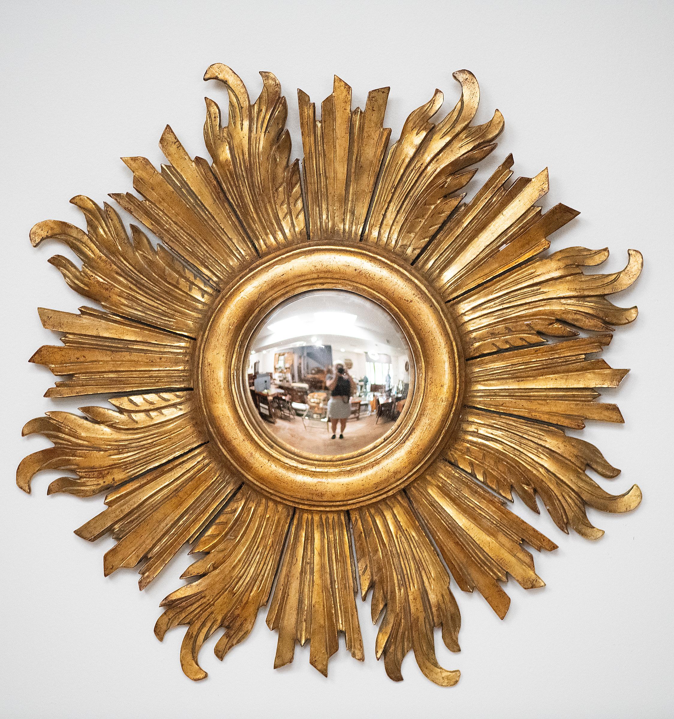 A lovely French gilt sunburst (or starburst) convex mirror with beautifully gilded wooden rays arranged around the mirror plate glass center.  Alternating straight and longer curved rays.

Diameter 22.75 inches