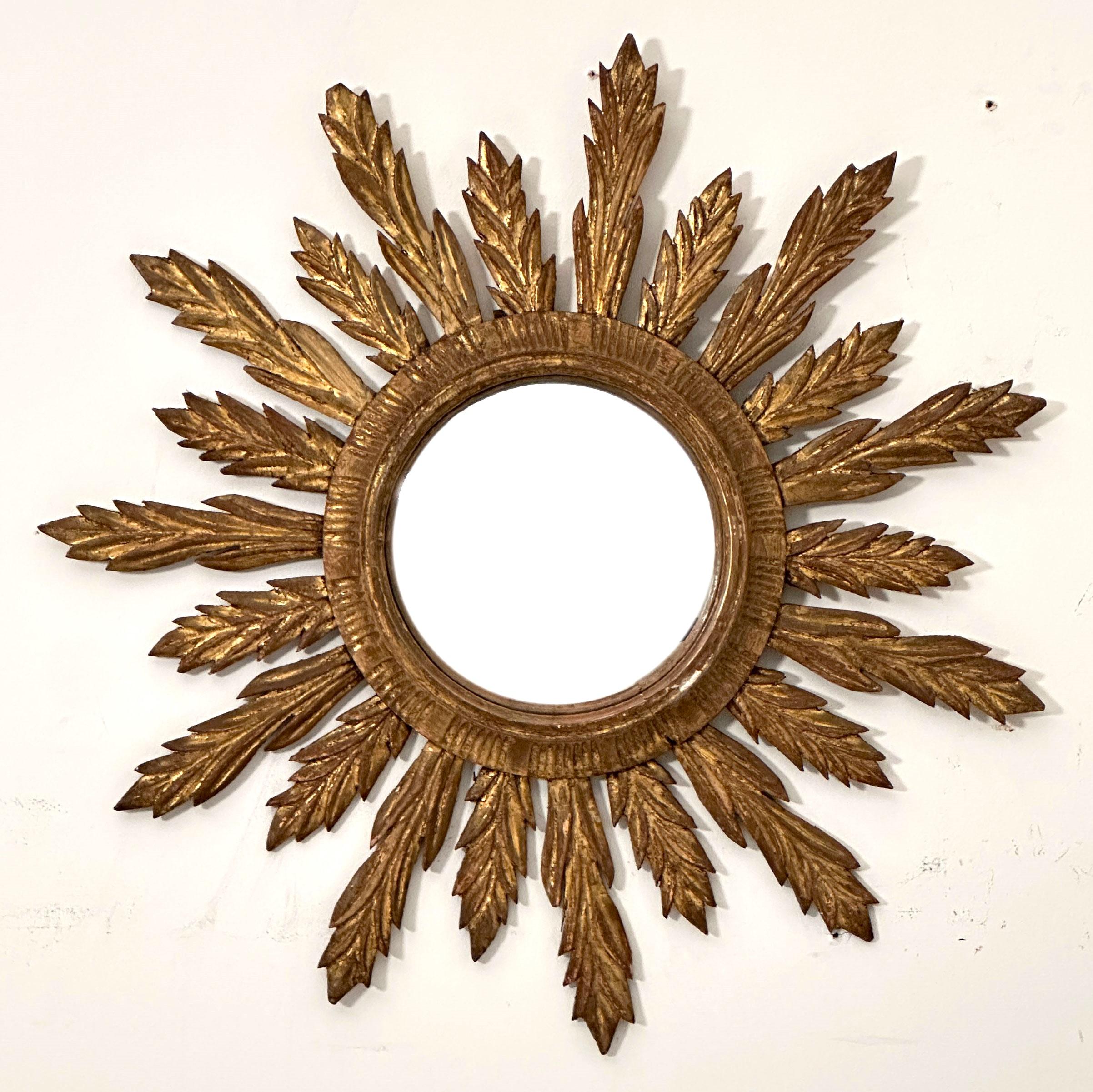 A lovely French convex gilt sunburst (or starburst) mirror with beautifully gilded wooden rays arranged around the convex mirror plate glass center.

Diameter 28.13 inches