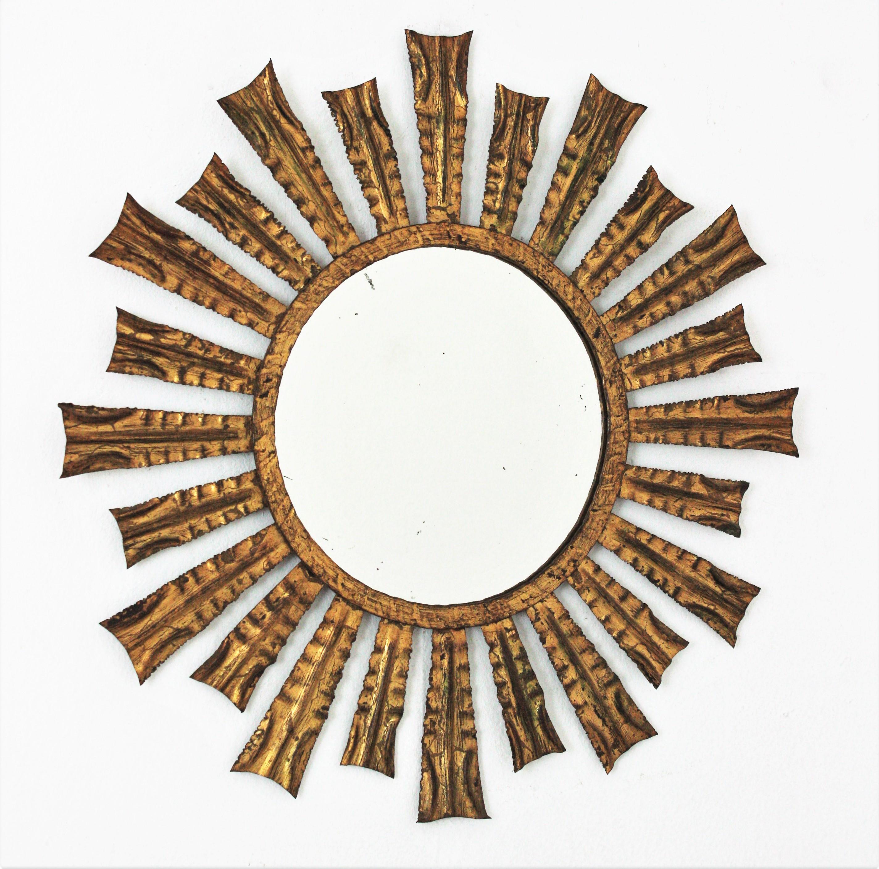 One of a kind Hand-Hammered Sunburst Mirror, Iron, Gold Leaf, France, 1950s.
Eye-catching gilt metal sunburst mirror with alternating rays in two sizes. Richly adorned by the hammer work. Nice aged patina showing its original gold leaf
