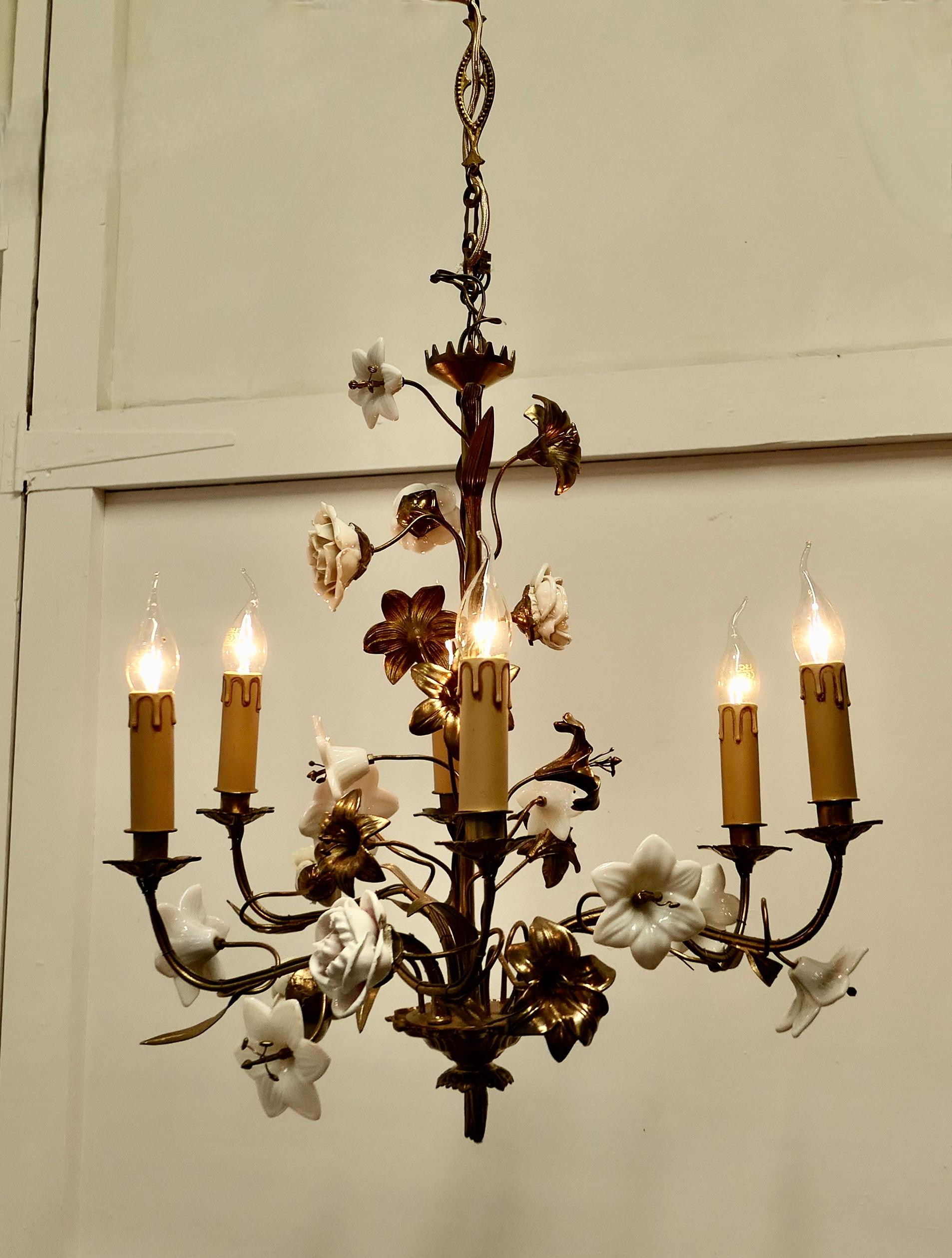 French Gilt Toleware and Floral Ceramic 6 Branch Chandelier

This is a very old and attractive dainty piece, the toleware has a gilded finish, the central column and 6 arms are hung with flowers, some of these  are the original Gilt and Porcelain
