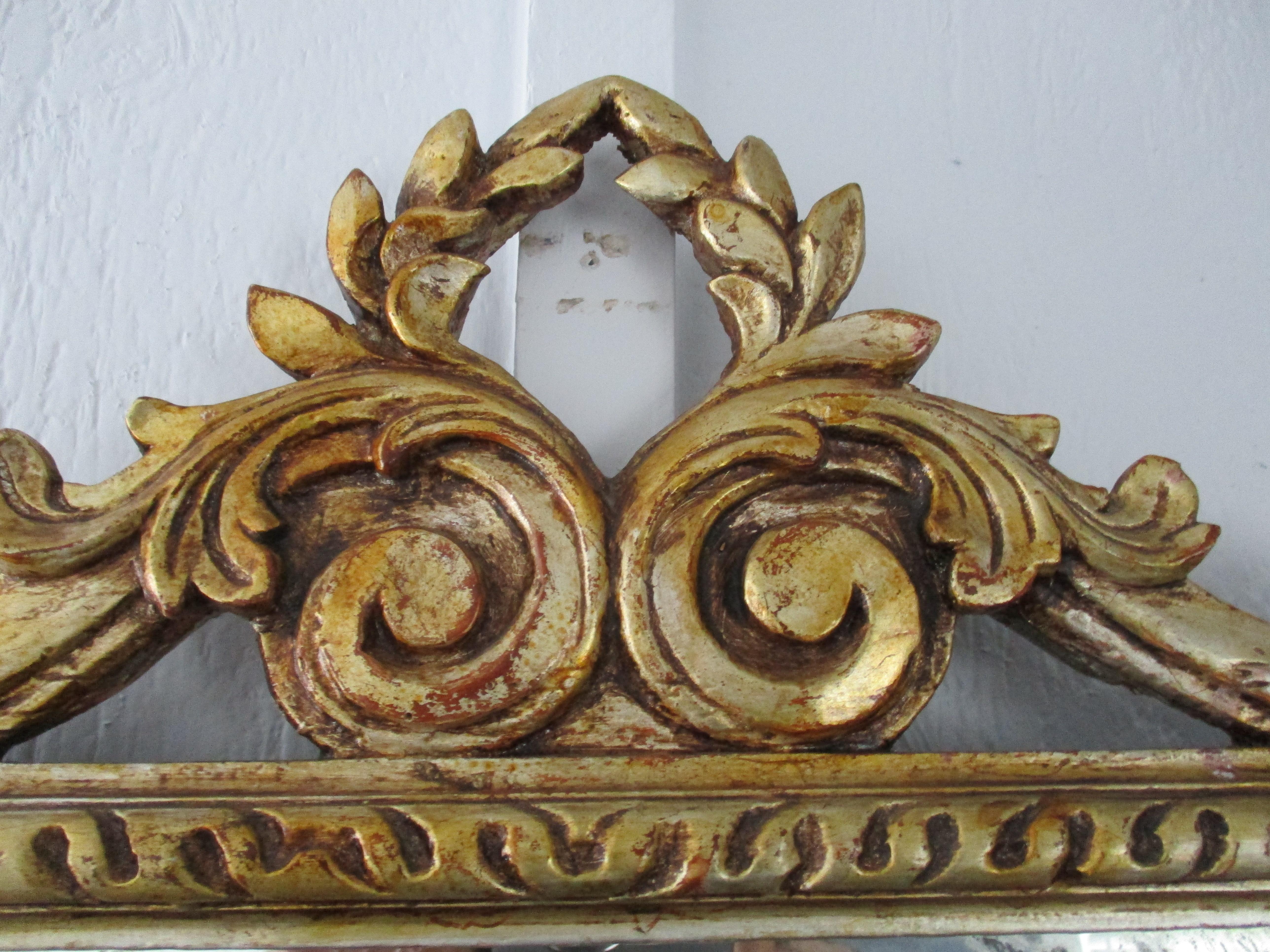 Beautiful French tri-panel carved giltwood console mirror with original mercury glass. This mirror can sit on a console, mantel, etc. or be hung.