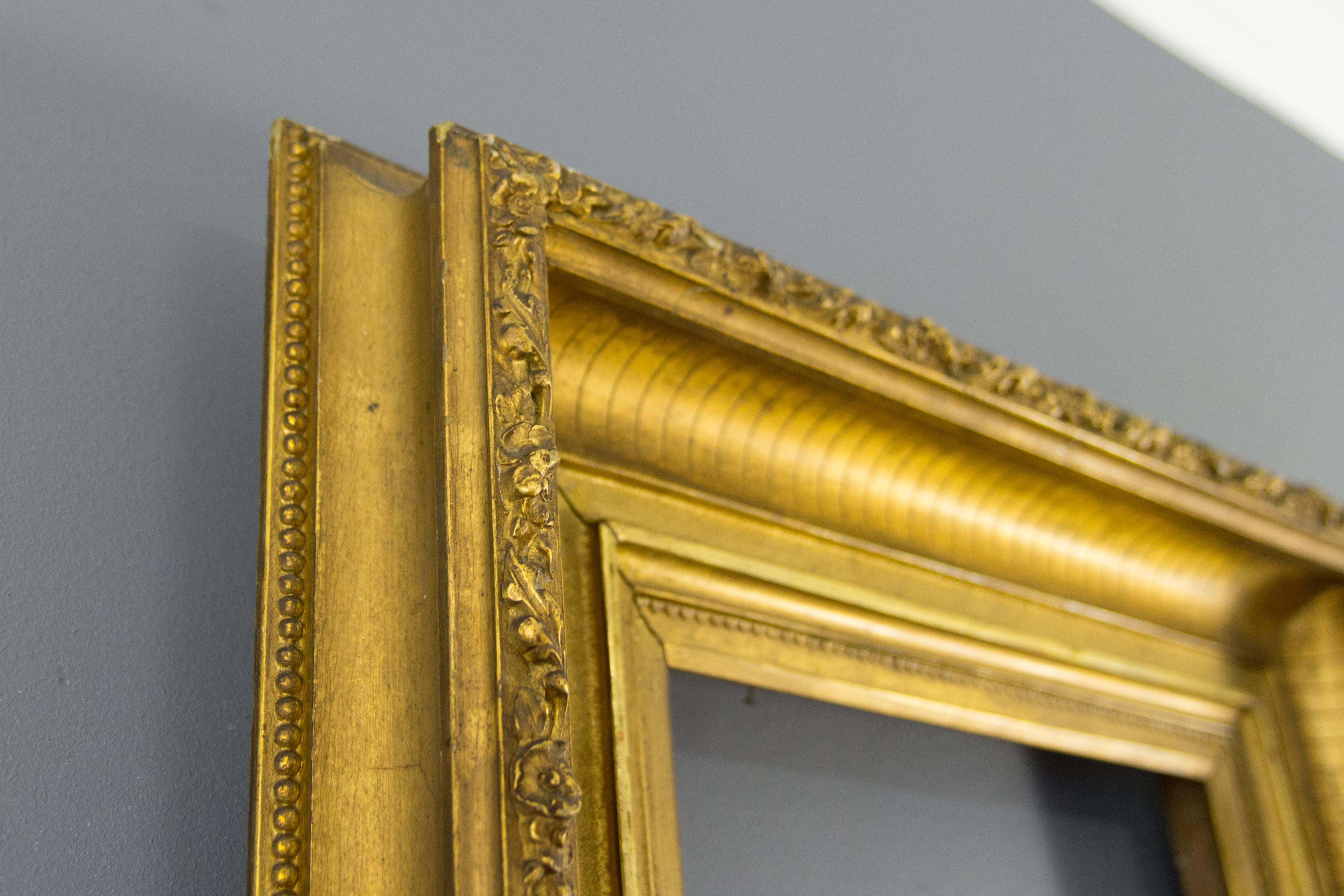 Beautiful French giltwood and gesso picture frame or mirror frame, late 19th century.
This spectacular antique frame features a fluted border, decorated with flowers and leaves on the outer edge.
Dimensions: Height 54.5 cm / 21.46 in, width 50.5 cm