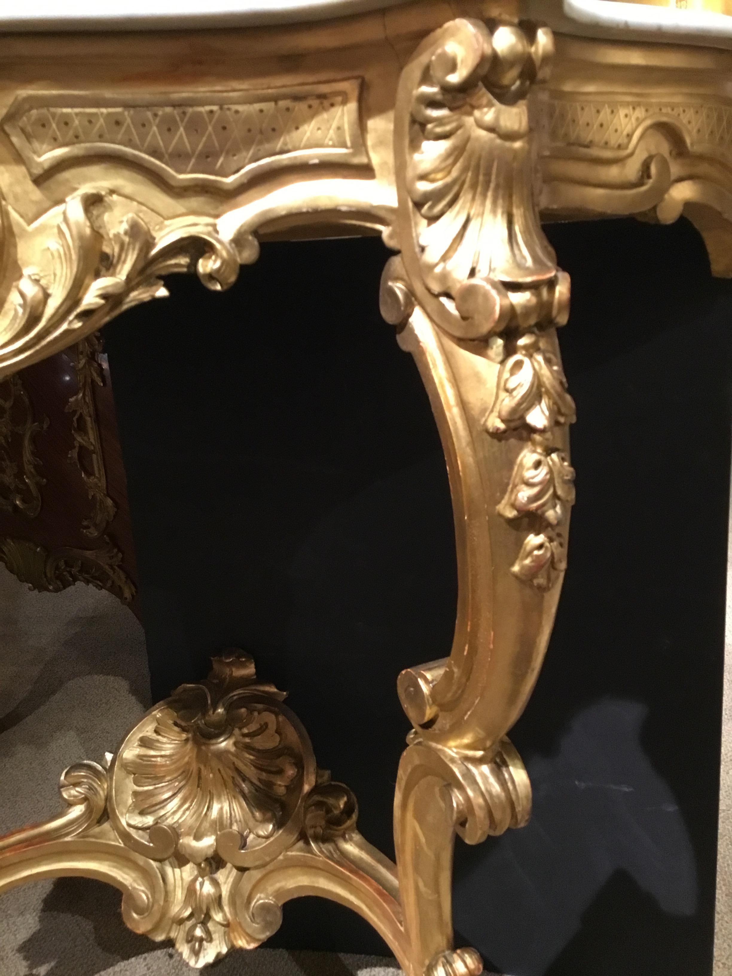 Giltwood console with original gilding with a fine patina! Superior carving technique with a central
shell carving centered in the front of the console and also centered on the curved stretcher.
The marble is original and is without breaks or