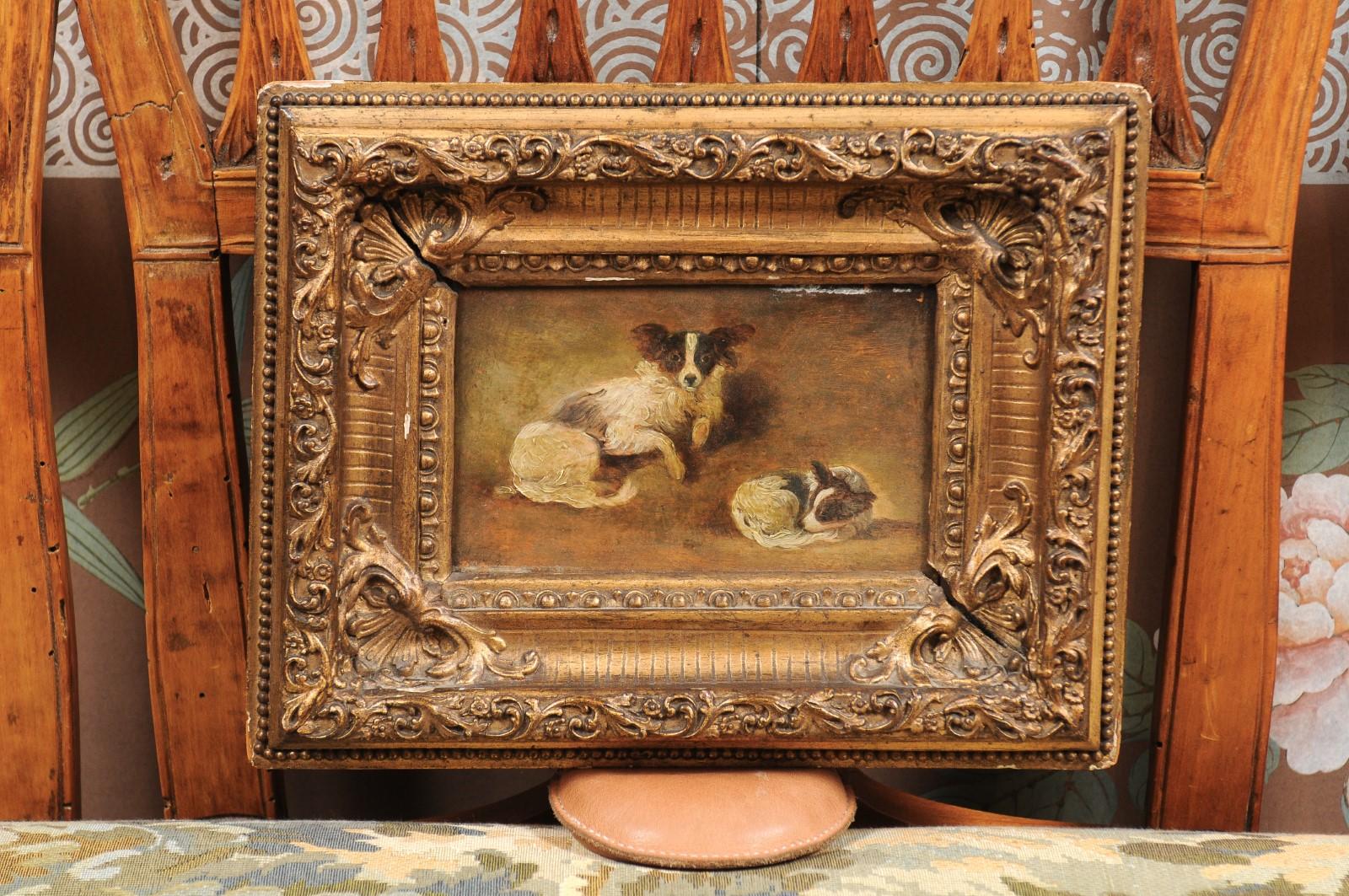 A giltwood framed oil on panel painting of 2 papillon dogs. The painting dating from the late 19th century and French and origin.