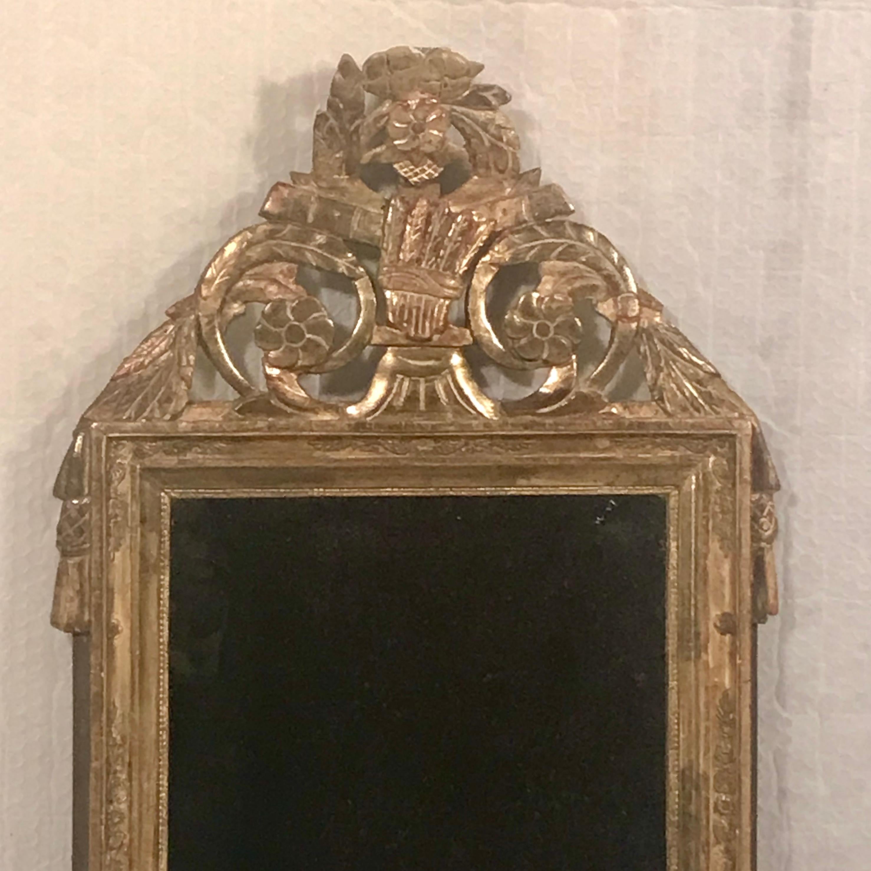 Entrez dans le monde somptueux de l'artisanat français avec notre miroir en bois doré des années 1780-1800, méticuleusement préservé. Cette pièce exquise incarne l'opulence et la sophistication de son époque, avec une symphonie de détails sculptés à