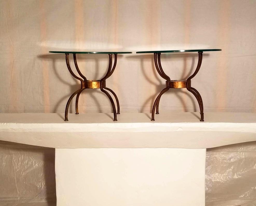A pair of French wrought iron gilt end tables. 
The spider leg frames radiate out from thick cast amber glass discs 14 cm. x 2.5 cm. thick.
The tables are in good condition.