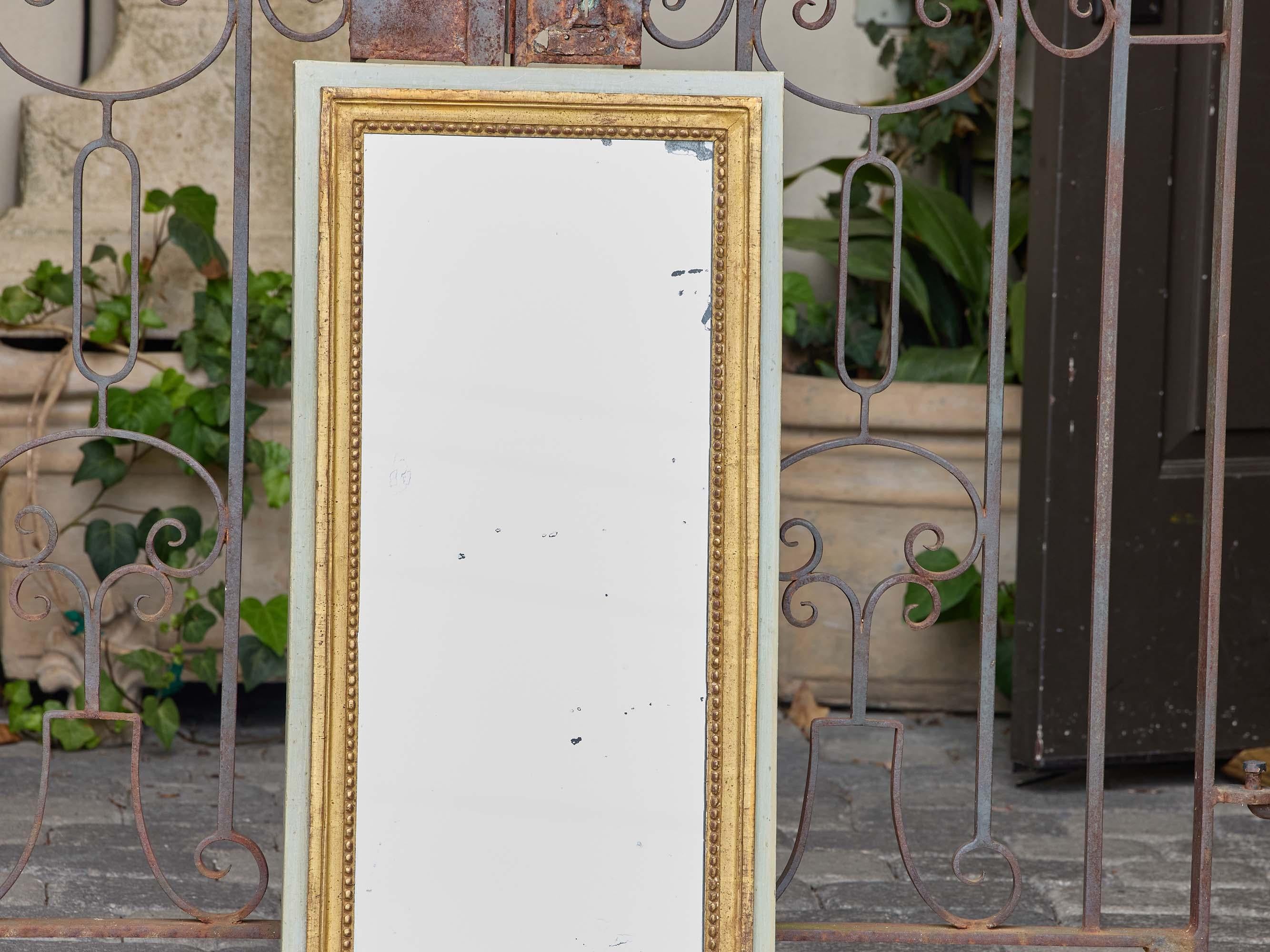 Un alto specchio da parete francese in legno dorato e dipinto del 1920 circa, che combina l'eleganza dei primi anni del XX secolo con proporzioni pulite e versatili. La forma rettangolare è incorniciata da un bordo esterno nitido in una morbida