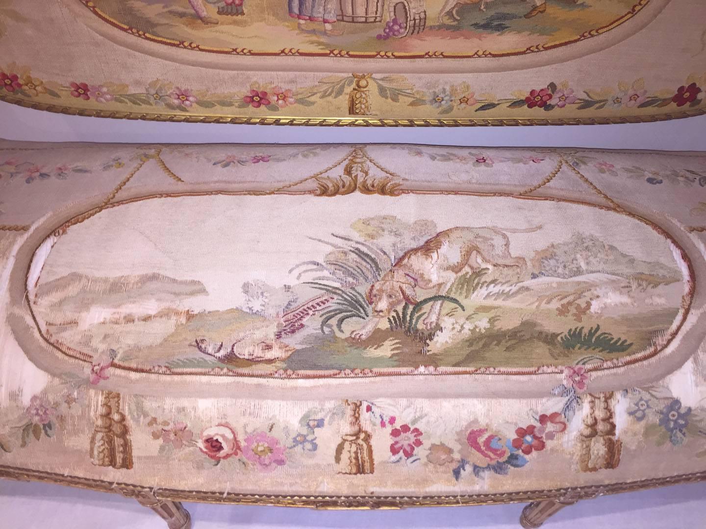 Fünfteilige französische Salongarnitur aus Vergoldung und Gobelin im Louis-XVI-Stil, um 1890.
Bestehend aus einem Canape und vier Fauteuils, die mit französischen Aubusson-Wandteppichen gepolstert sind, die Kinder und Tiere in einer ländlichen Szene