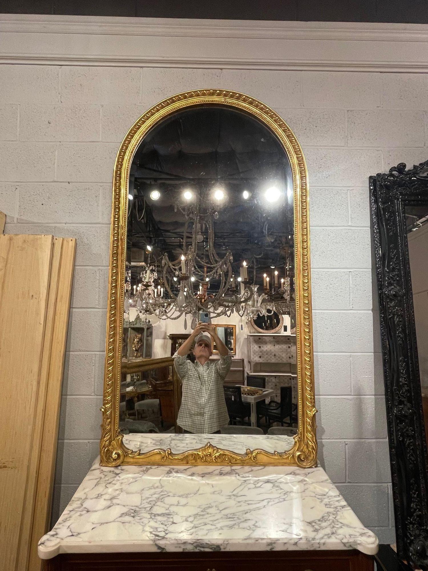19th century French Louis XV style carved and giltwood arch top mirror. Circa 1870. A fine addition to any home!.