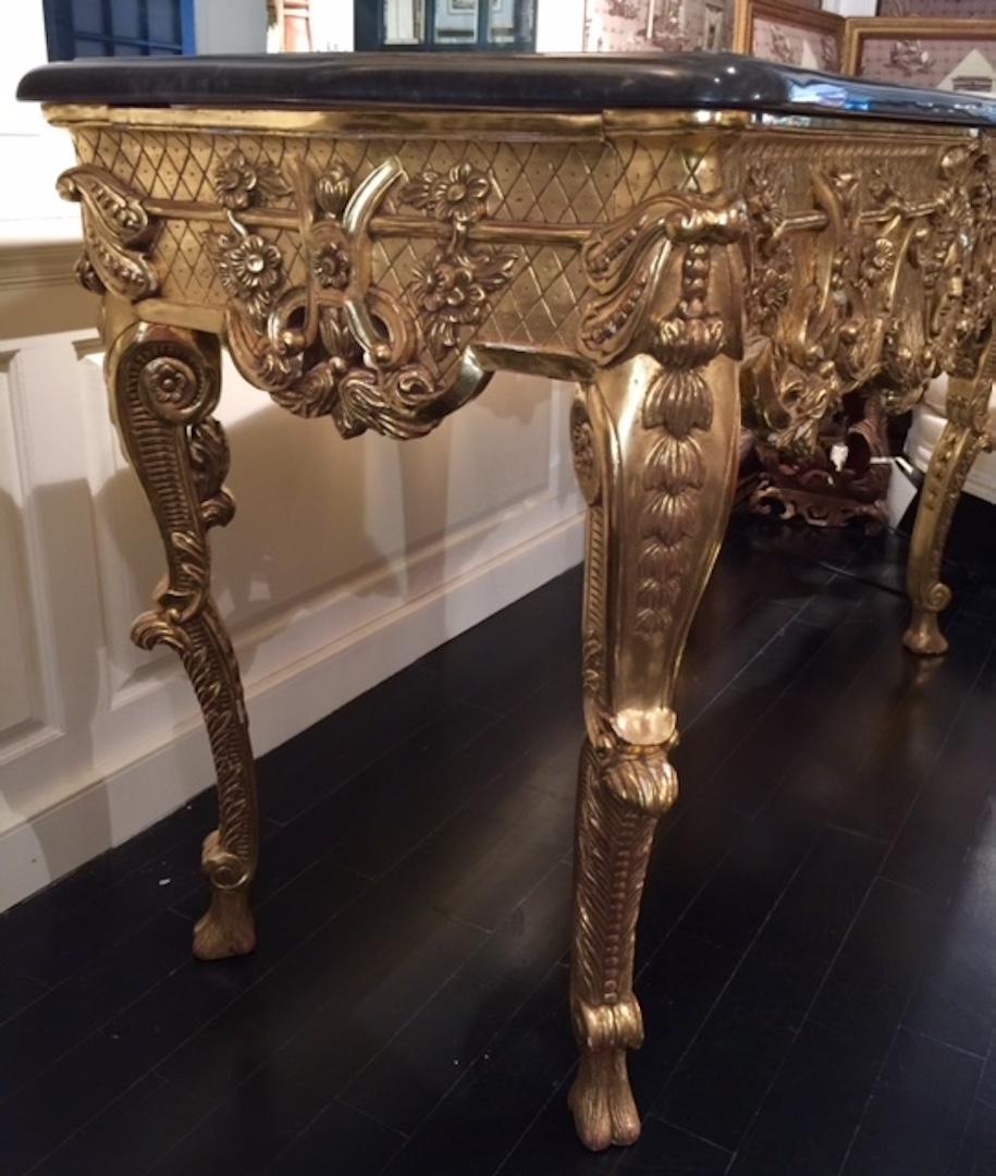 French 20th century Louis XIV style, giltwood and plaster center table with black marble top. This high French 