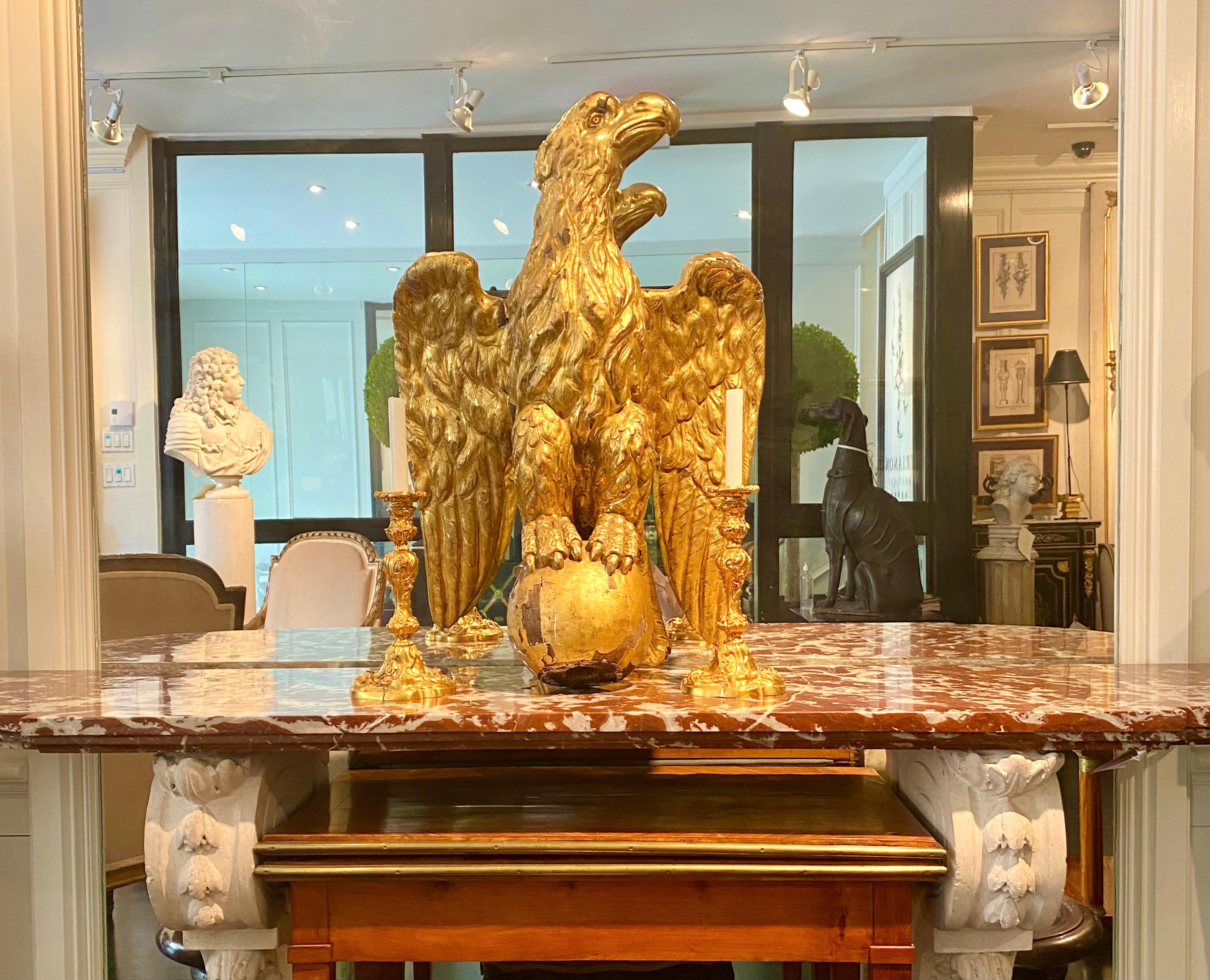 Rare French, 19th century, Empire. Large size carved wood and gesso gilt eagle, with its full body, swept back wings, pronounced talons, perched on a ball. Important size.

Condition good for age, with cracks to gilding with some gesso and wood