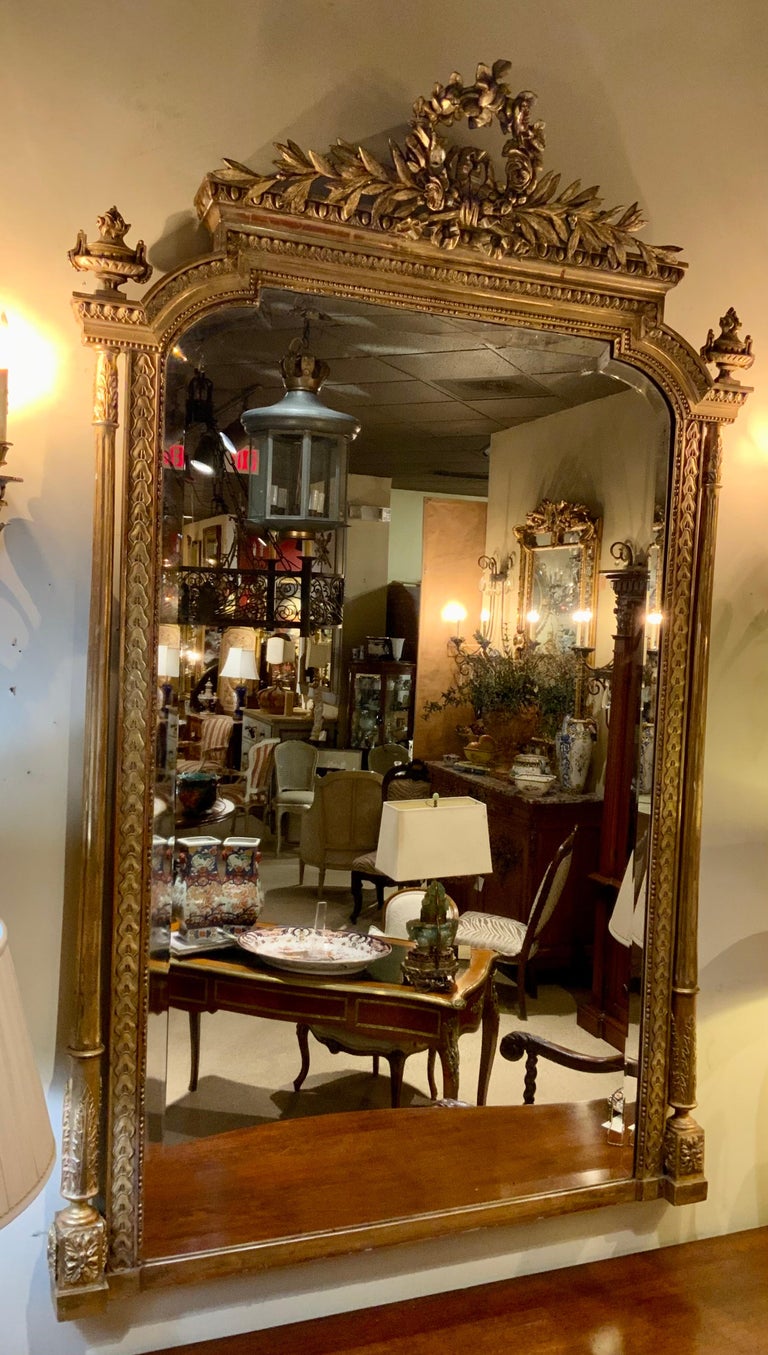 This exceptional mirror is well carved with original gilding in a fine
Gold patina. It has a wide bevel with original mirror plate. The mirror 
Plate is clear and without spots. A finely carved floral wreath is centered
At the top crest. A carved