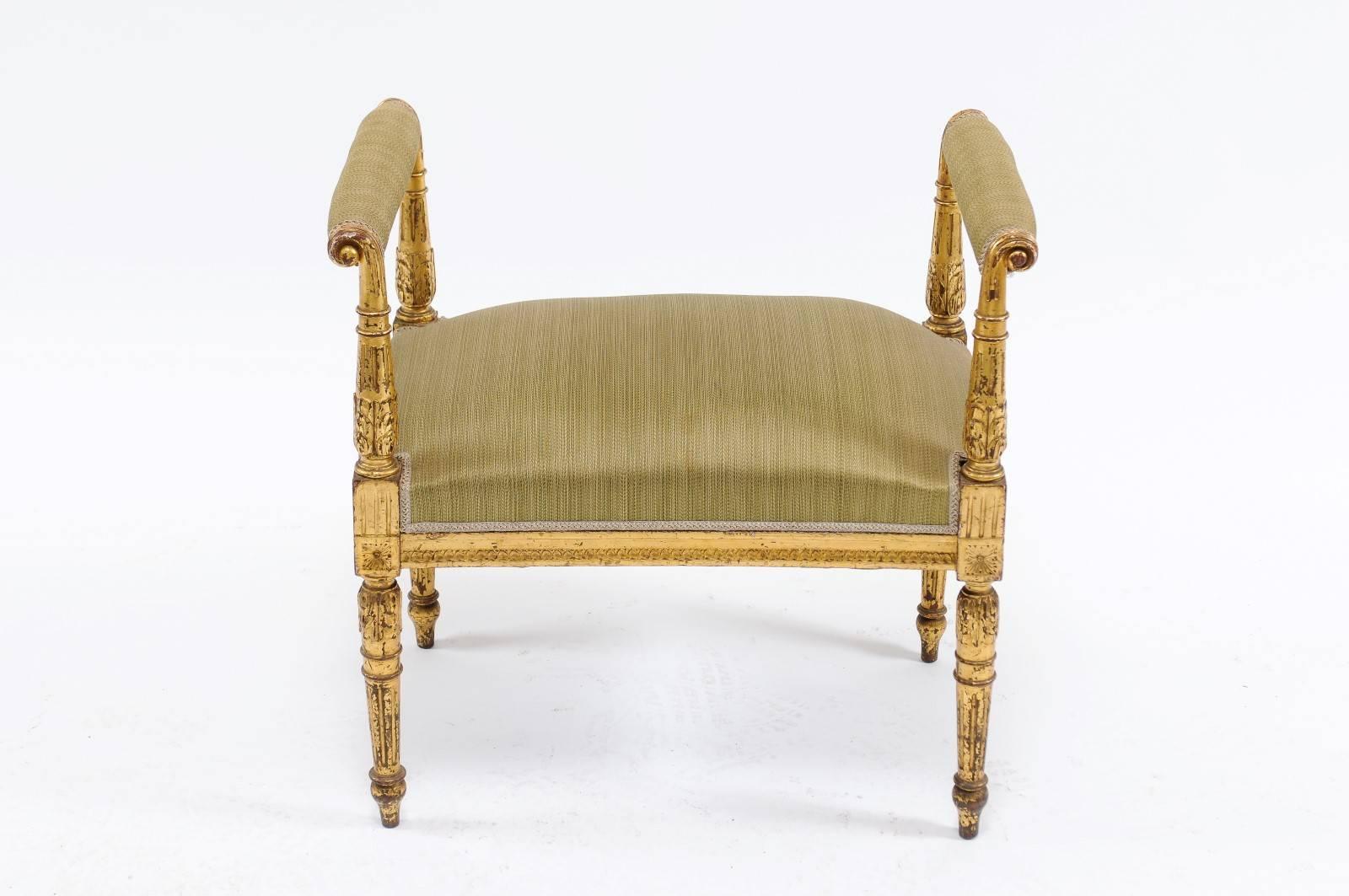 A French 19th century giltwood upholstered bench with out-scrolled arms, acanthus leaves and fluted legs. We found this darling little 19th century banquette at the Paris flea market and immediately fell in love. The delicate lines, intricate