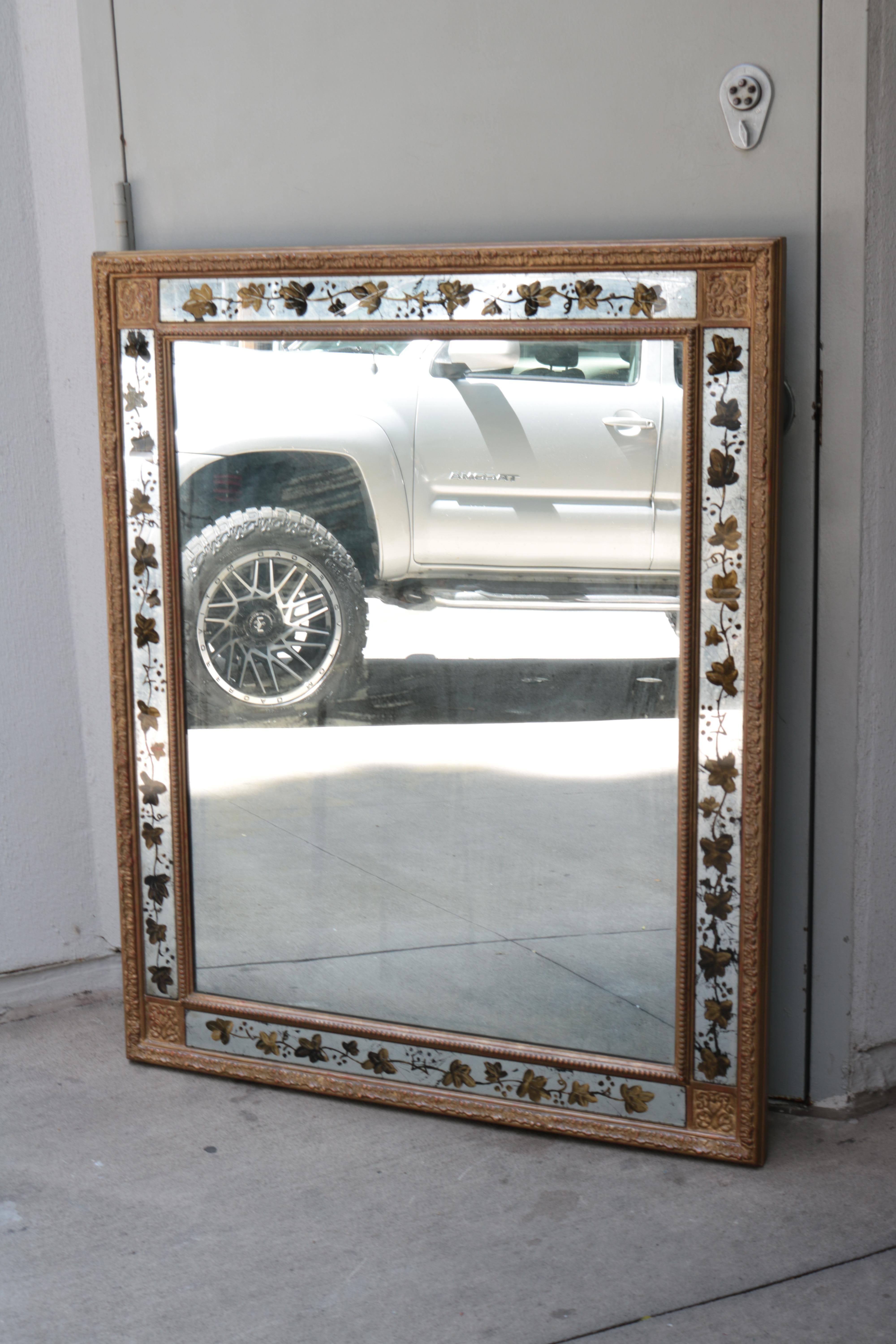 A French giltwood mirror with eglomise details. 
Carved giltwood frame with eglomise mirror panels.