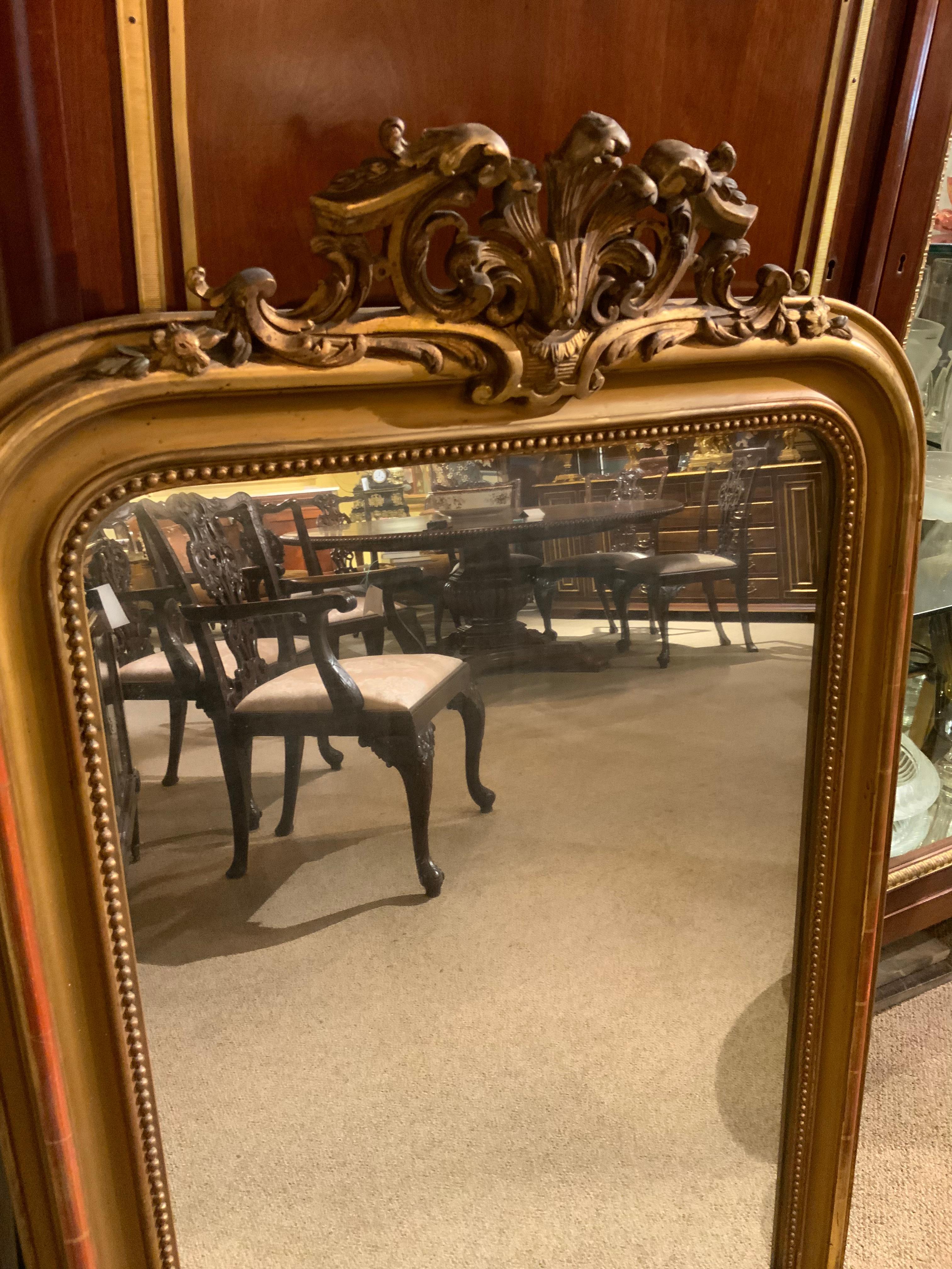 This antique piece has the original mirror and does not have spots.
The frame in giltwood is also original and has a beautifully aged
Patina showing elegant wear with some of the red under glow
Showing. The oval at the crest is very graceful and