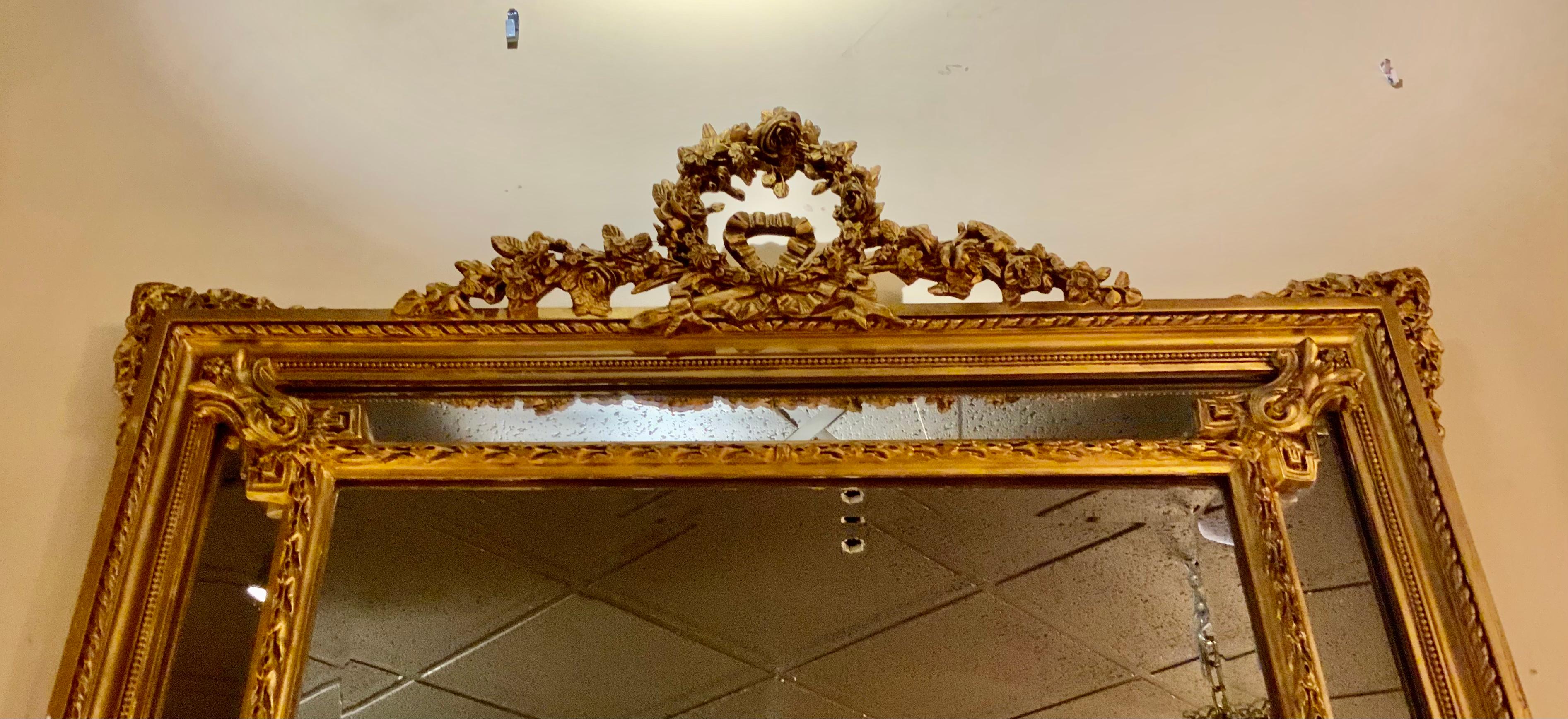 The original gold gilt patina is very soft but also vivid. The foliate garland 
In a circular sphere is positioned at the crest of this piece. The double
Framework also enhances the beauty of this sophisticated mirror.
It has a wide bevel and