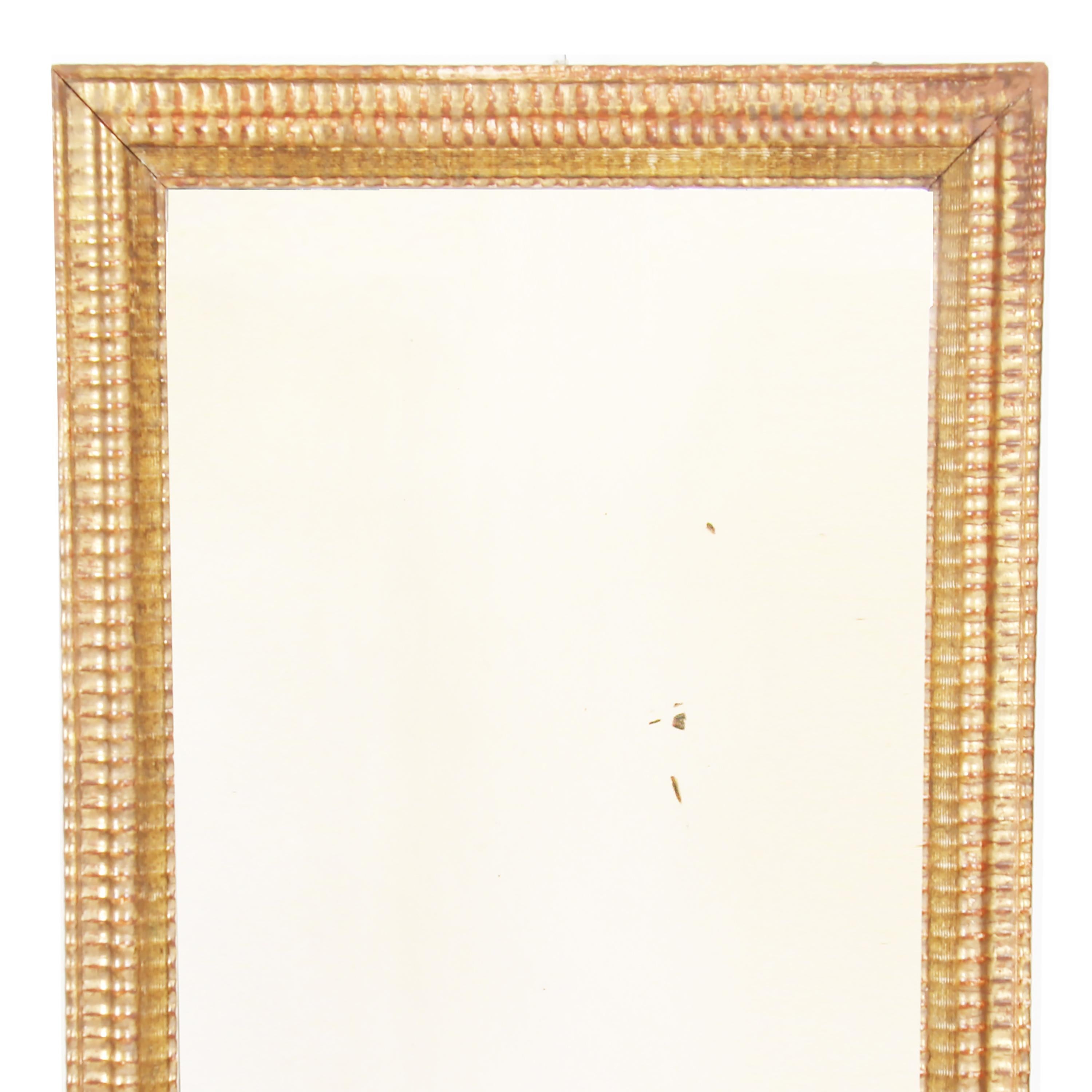 French 19th century, giltwood mirror with a ripple design frame. With original mercury glass, this is a beautiful piece.