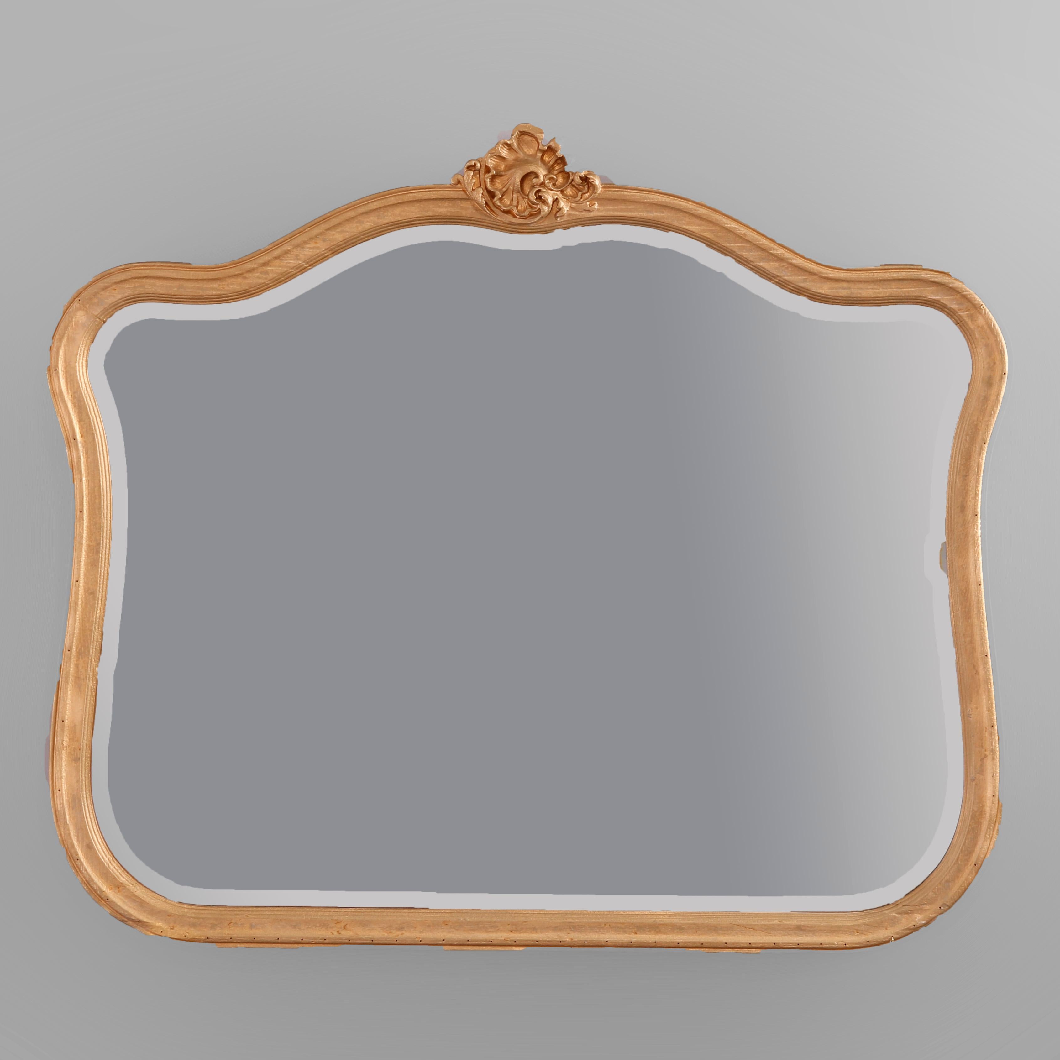 A French Rococo style wall mirror offers shaped form with giltwood frame having gadroon cartouche and housing beveled mirror, 20th century

Measures - 35.25'' H x 40.75'' W x 2.25'' D.

Catalogue Note: Ask about DISCOUNTED DELIVERY RATES available