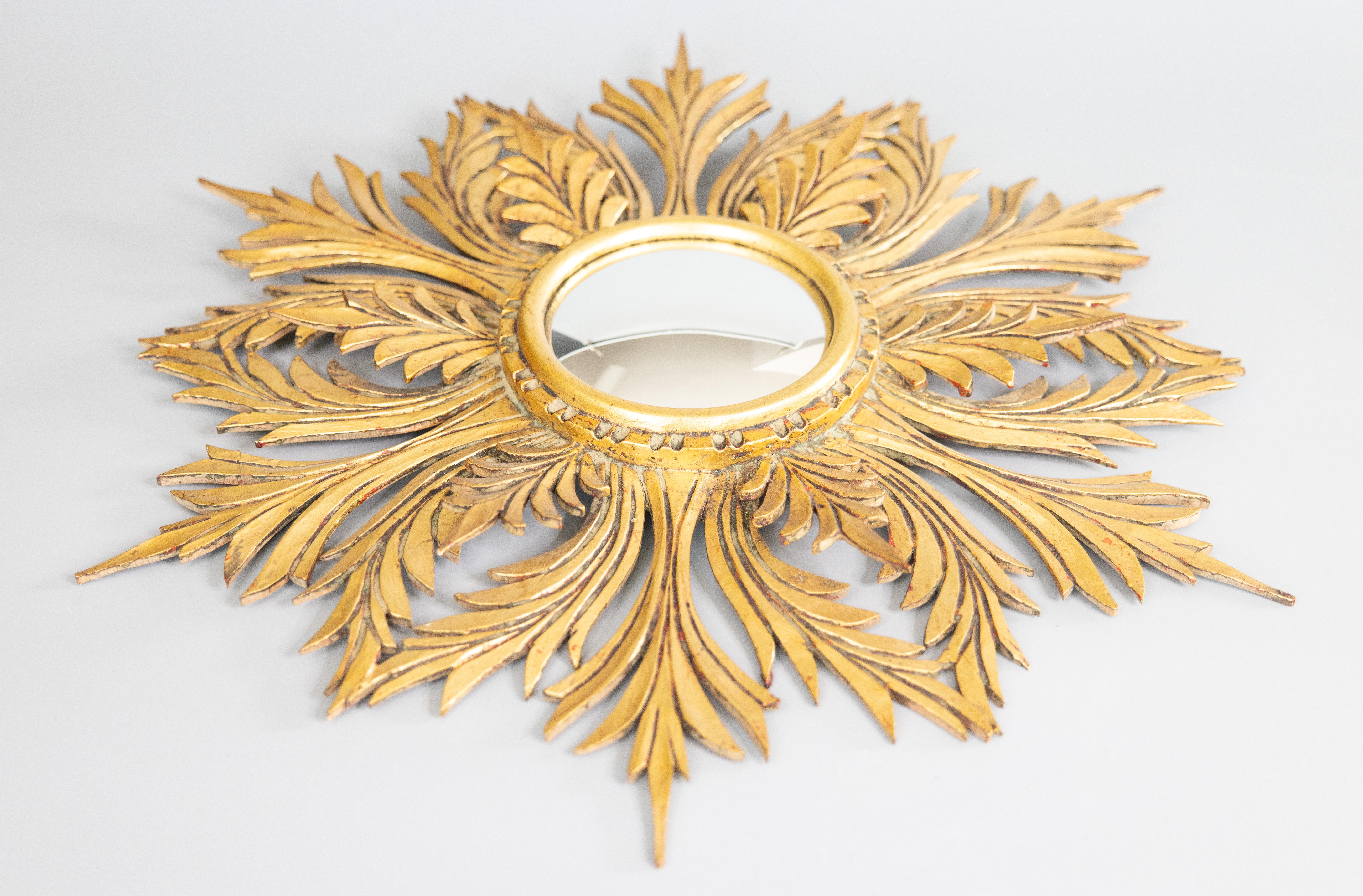 A rare beautifully carved Mid-20th Century French gilt wood sunburst / starburst mirror with the original convex mirror glass, circa 1950. This stunning mirror has a stylish snowflake design, lovely original gilt patina, and finely carved tiered