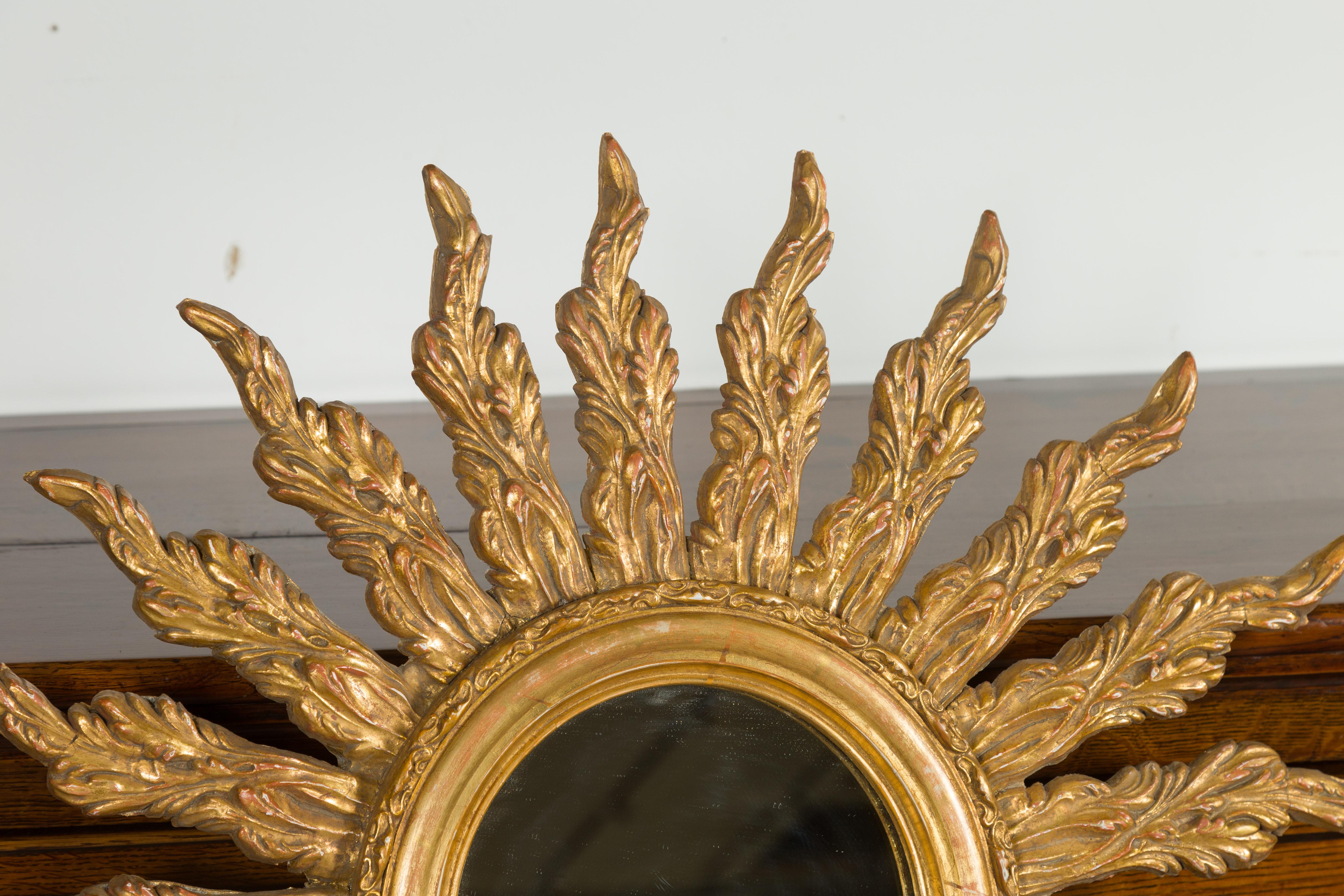 Carved French Giltwood Sunburst Mirror with Wavy Sunrays from the Mid-20th Century For Sale