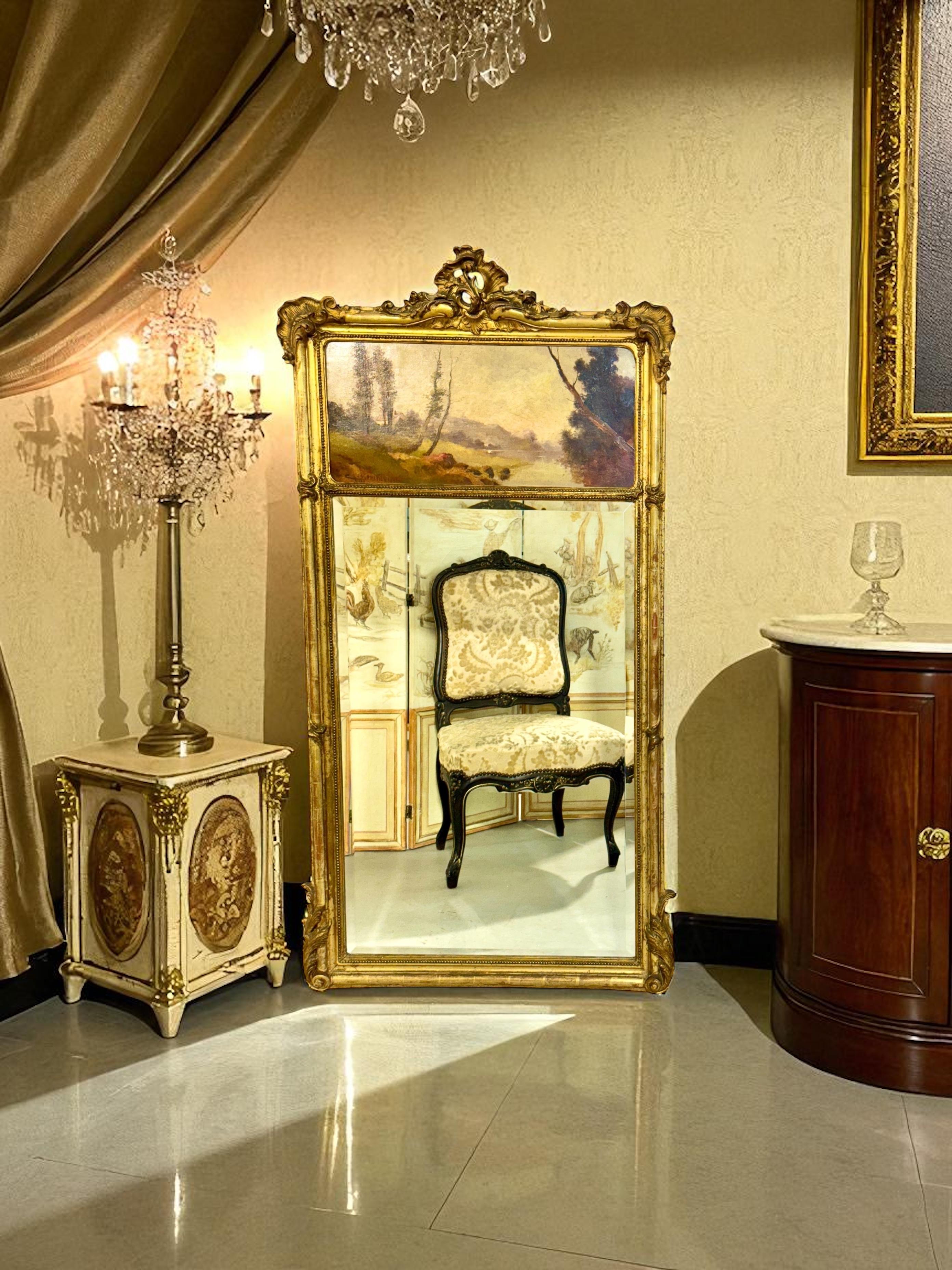 Este espejo trumeau francés de madera dorada, fechado en 1919 y firmado Crassous Fils, es un refinado ejemplo del arte decorativo de principios del siglo XX. El marco de madera tallada, ricamente adornado con hojas de acanto, bordes de cuentas y una