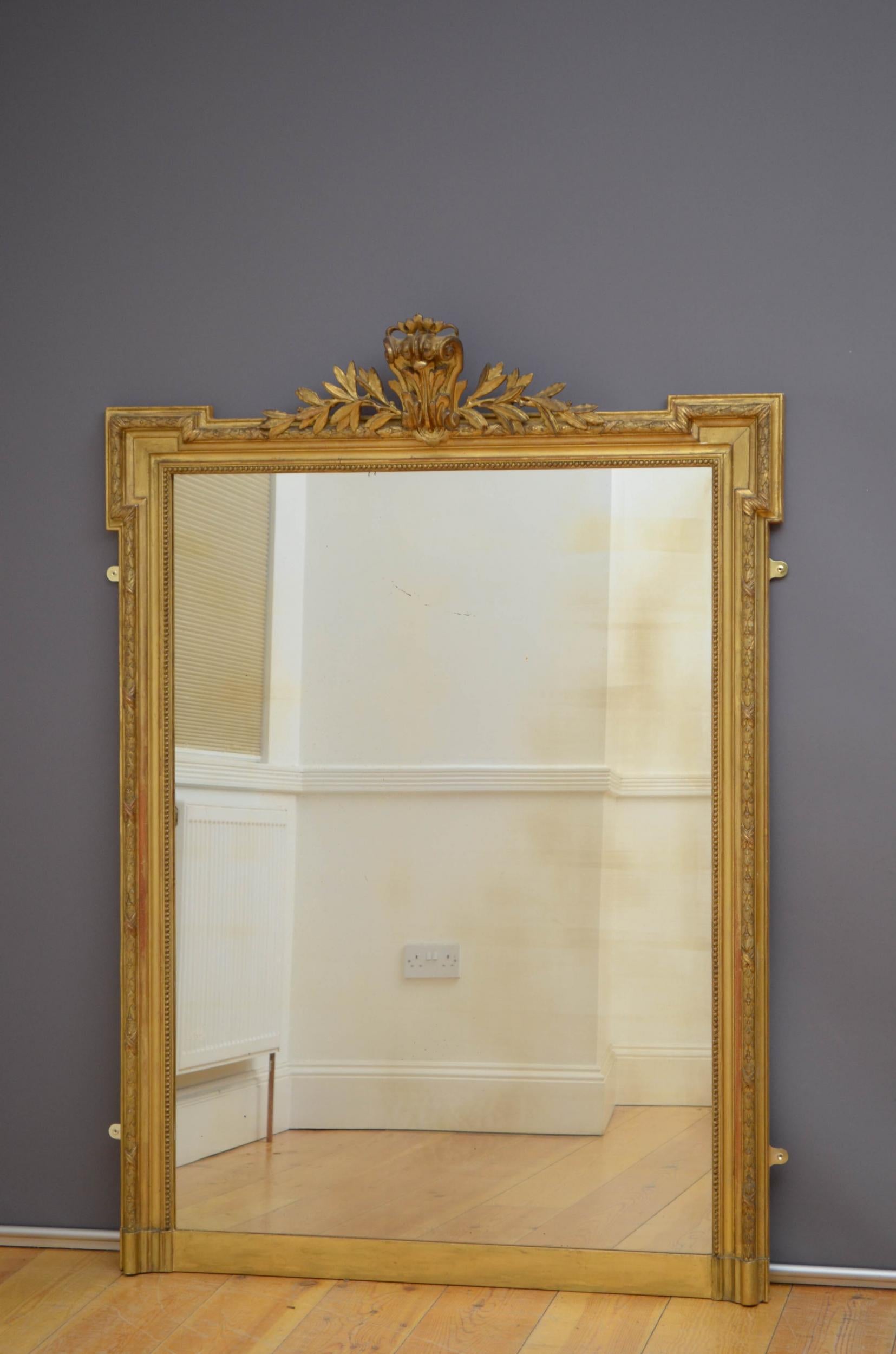 Sn4992 fine 19th century French gilded wall mirror, having original glass with some imperfections in moulded, beaded and gilded frame with flora centre crest and laurel decoration throughout. This antique mirror retains its original glass and