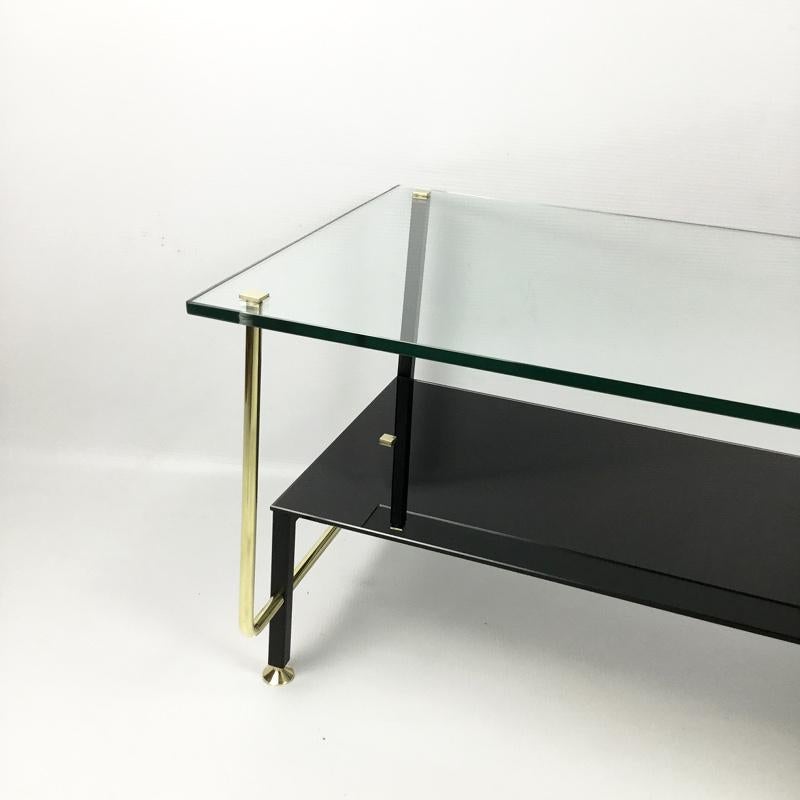 Coffee table with original clear glass top and black glass bottom with brass supports and legs.