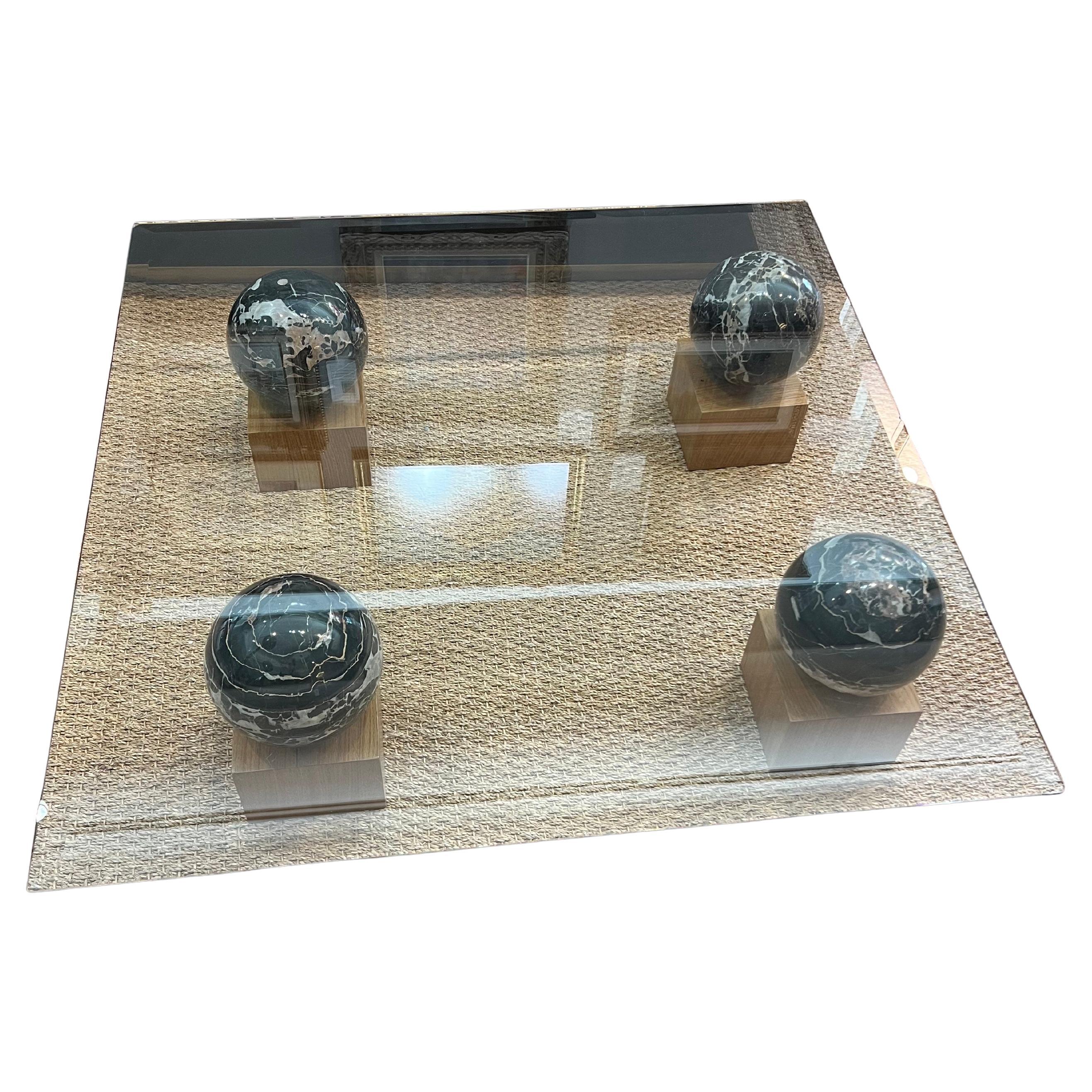 Table basse en verre et marbre

La table basse a un plateau en verre épais et est soutenue par 4 boules de marbre massif placées sur des supports en bois. 

 Très bon état, restauré.
France, C.C.
39” x 39” x 13”
