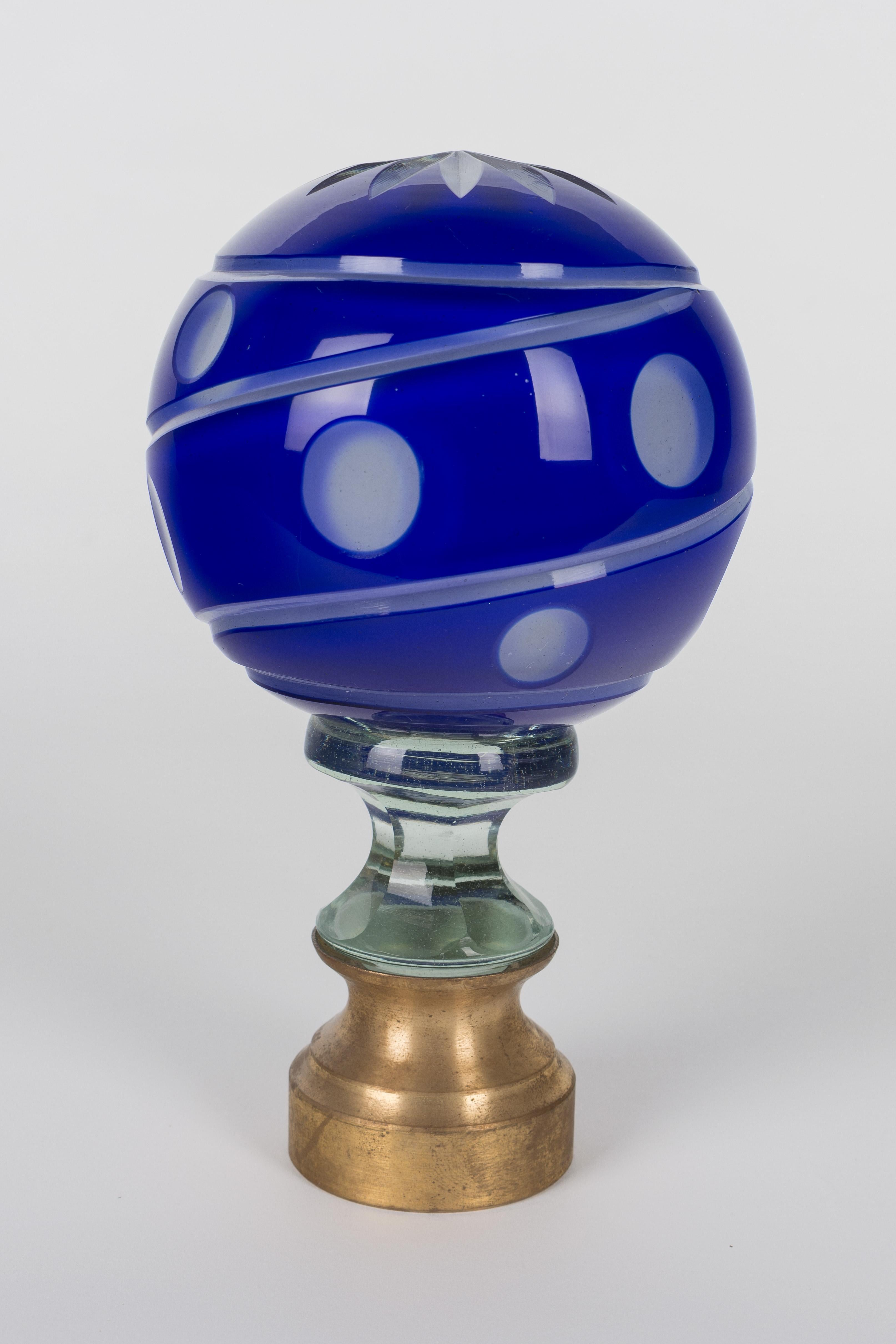 An early 20th century French glass newel post finial or boule d'escalier. These wonderful finials were used as decorative elements at the bottom of a staircase on the newel post. This one is made of two layers of cased glass with the cobalt glass