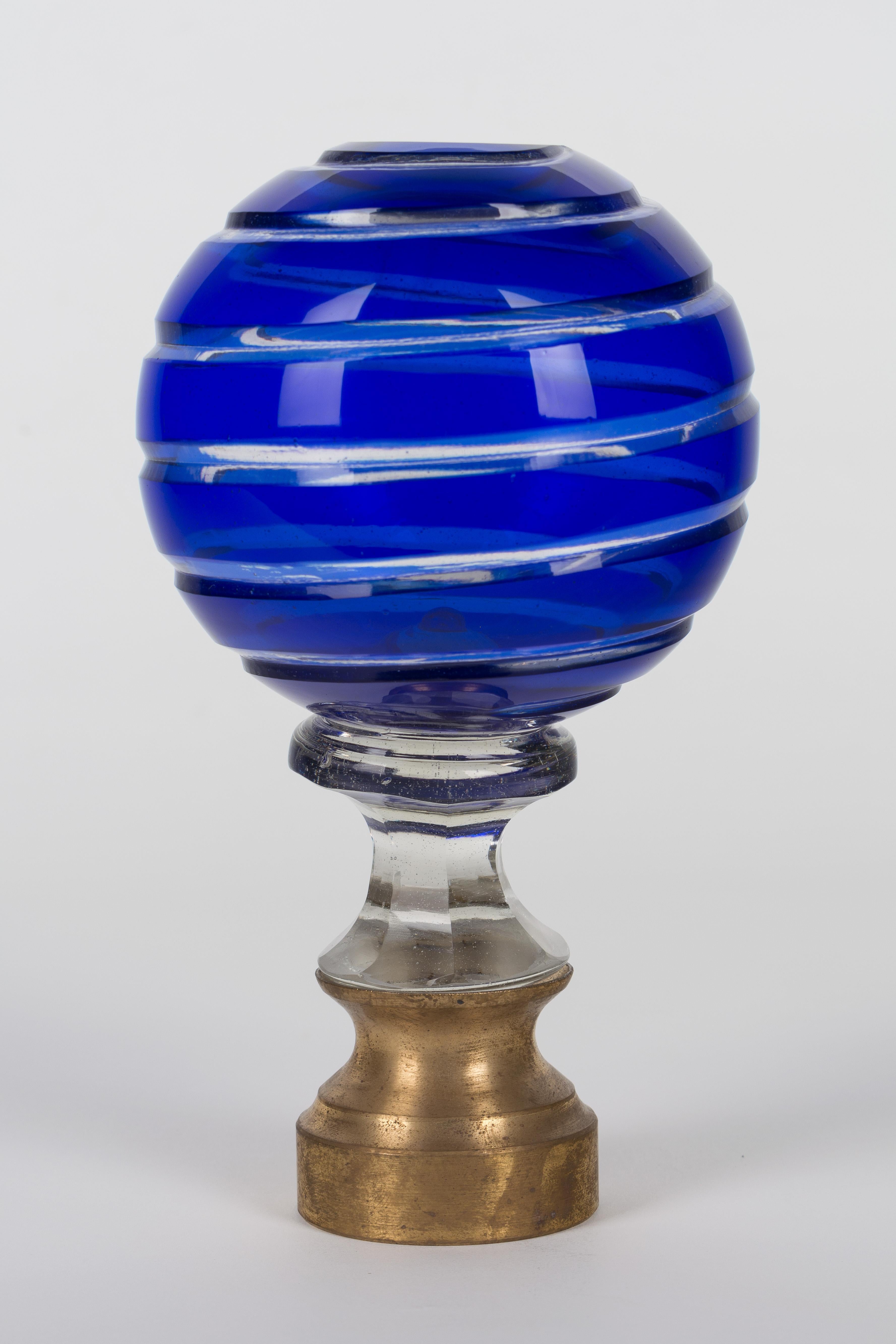 An early 20th century French cobalt colored cut glass newel post finial or boule d'escalier. These wonderful finials were used as decorative elements at the bottom of a staircase on the newel post. Brass hardware base. We have several others