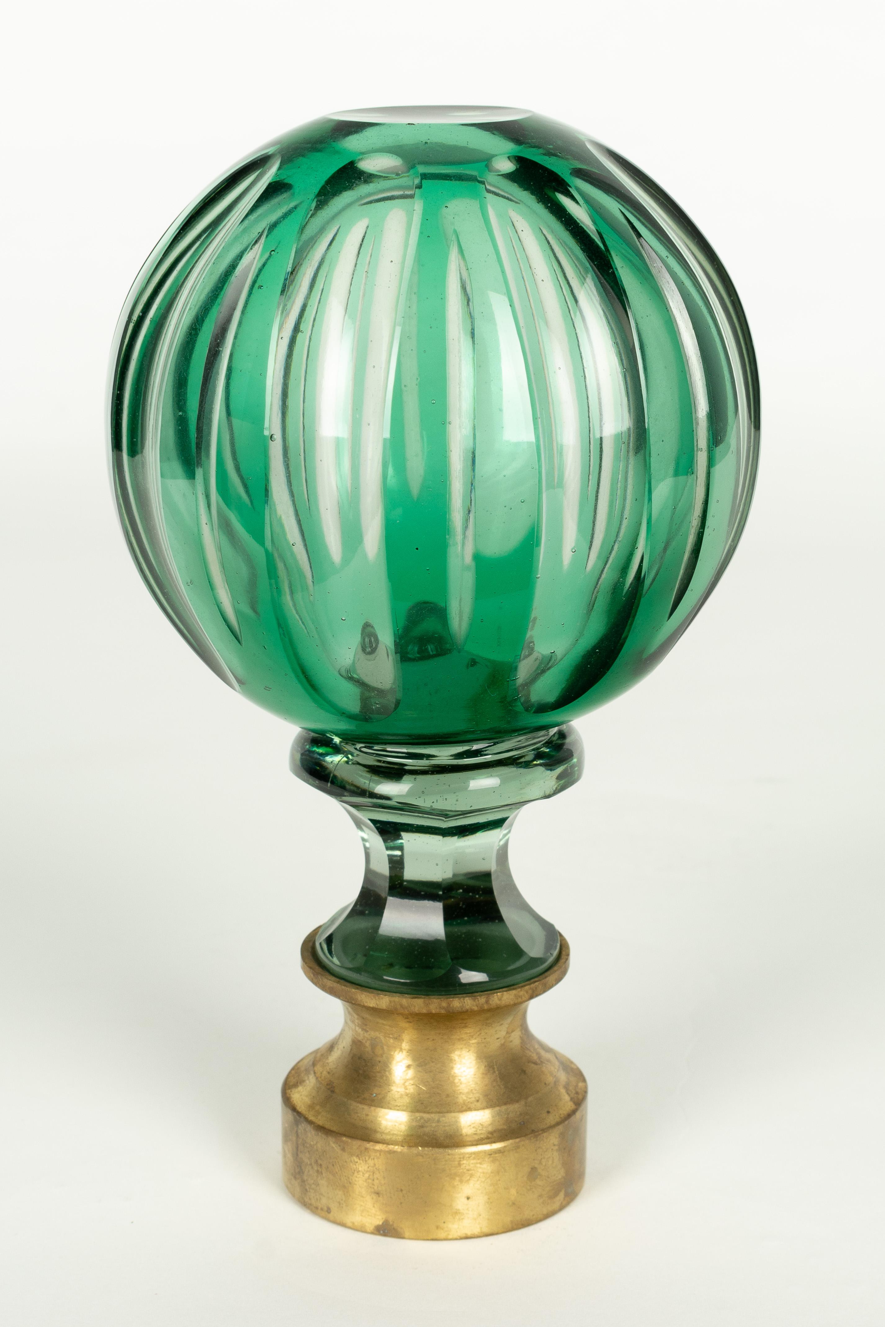 A French crystal newel post finial or boule d'escalier. Made of two layers of cased glass with the green glass surface cut back to the clear glass underneath. Brass hardware base. These wonderful finials were used as decorative elements at the