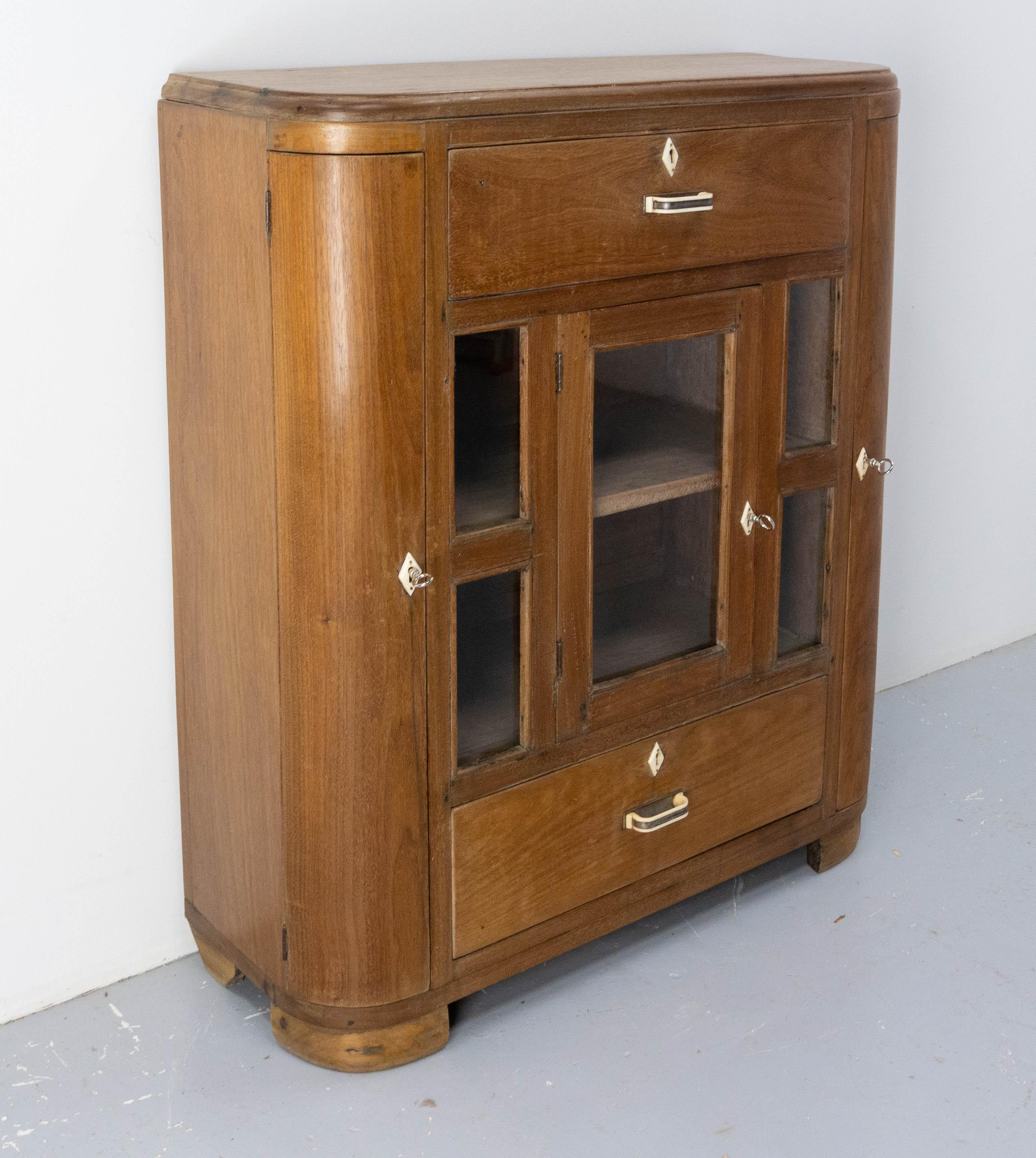 This French cabinet in massive teck with glass vitrine two drawers and two doors is very original with its rounded corners. 

Good condition.

Shipping:
35 / 87 / 102 cm 63 kg.