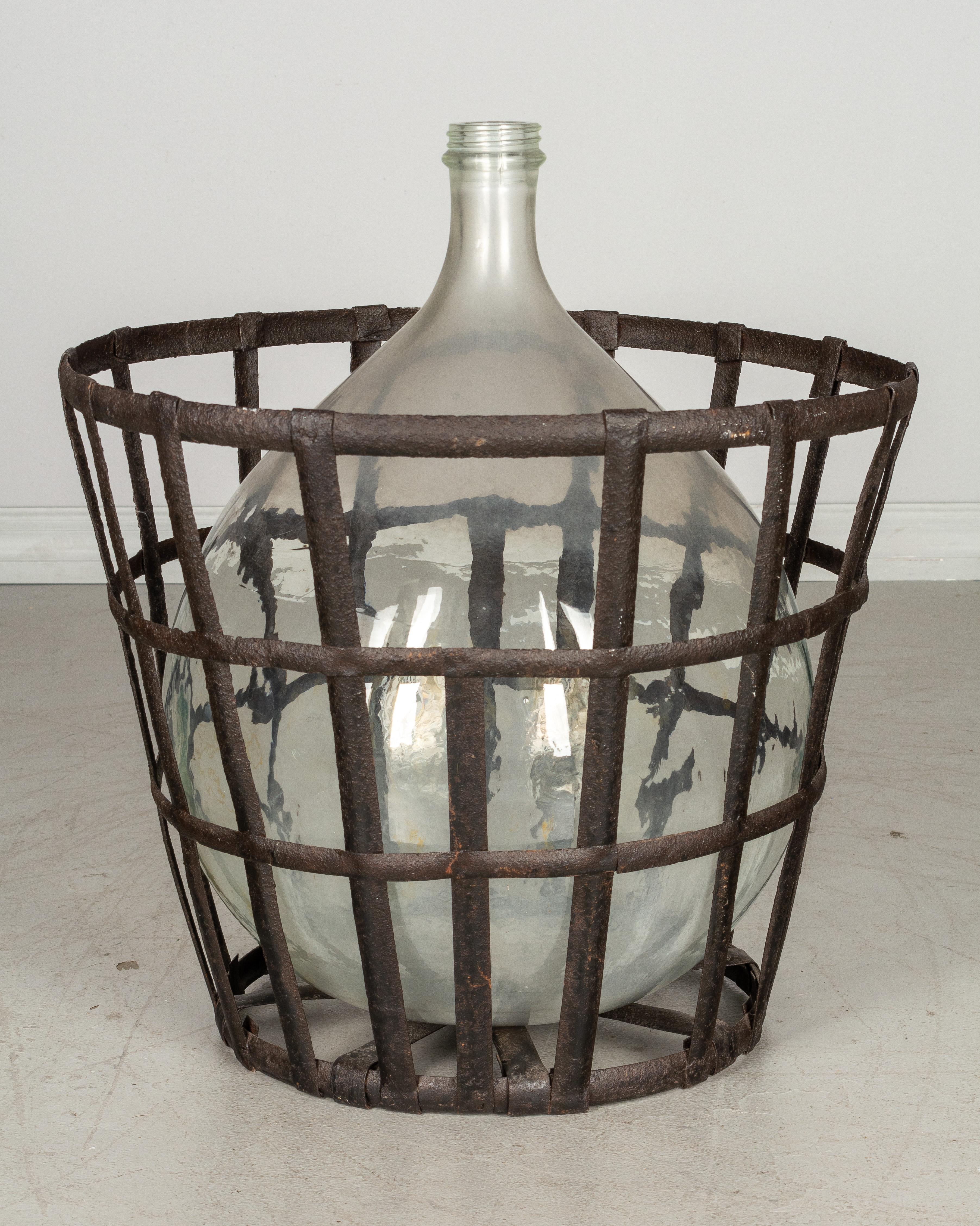 French Provincial French Glass Demijohn Bottle in Metal Basket