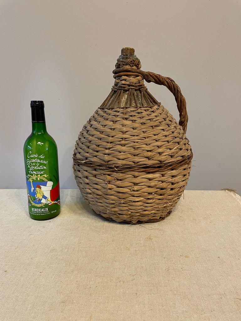 French Glass Demijohn Bottle in Woven Basket at 1stDibs