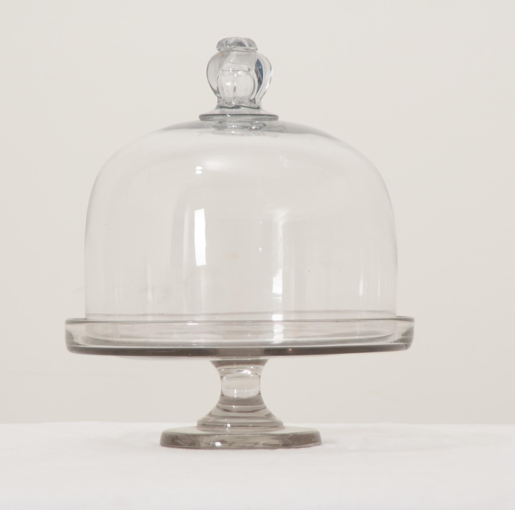 A large and impressive hand blown cake or cheese display, most likely used in a retail shop. A large bell shaped dome with knob sits over the pedestal base. Perfect for keeping your food protected on the counter. Be sure to view the detailed images