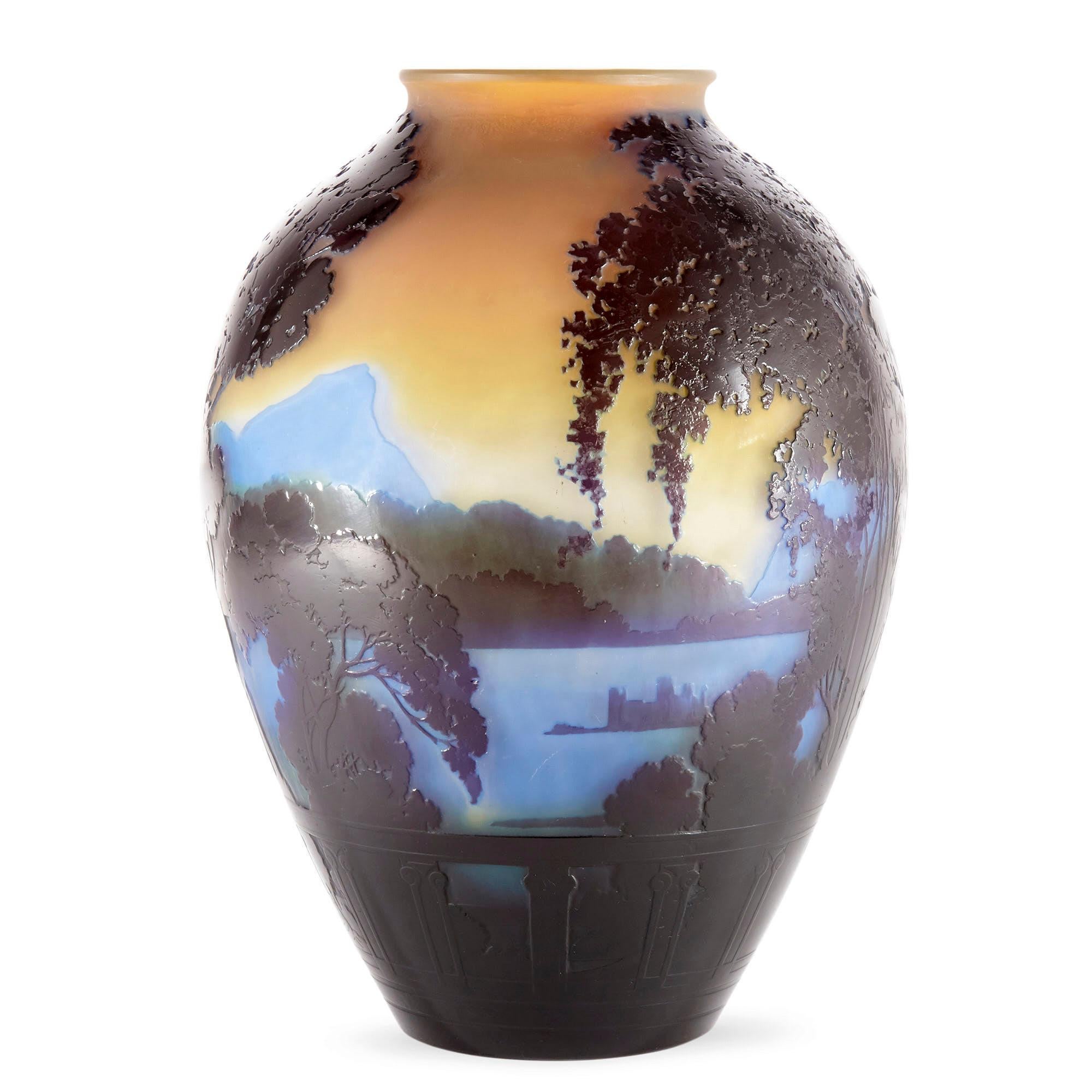 This exquisite Art Nouveau glass vase was crafted by the preeminent French artist and craftsman Émile Gallé. The vase depicts Lake Como in Italy as seen in twilight, the sky a warm orange-red, the lake’s water pale blue, and the tree’s in the