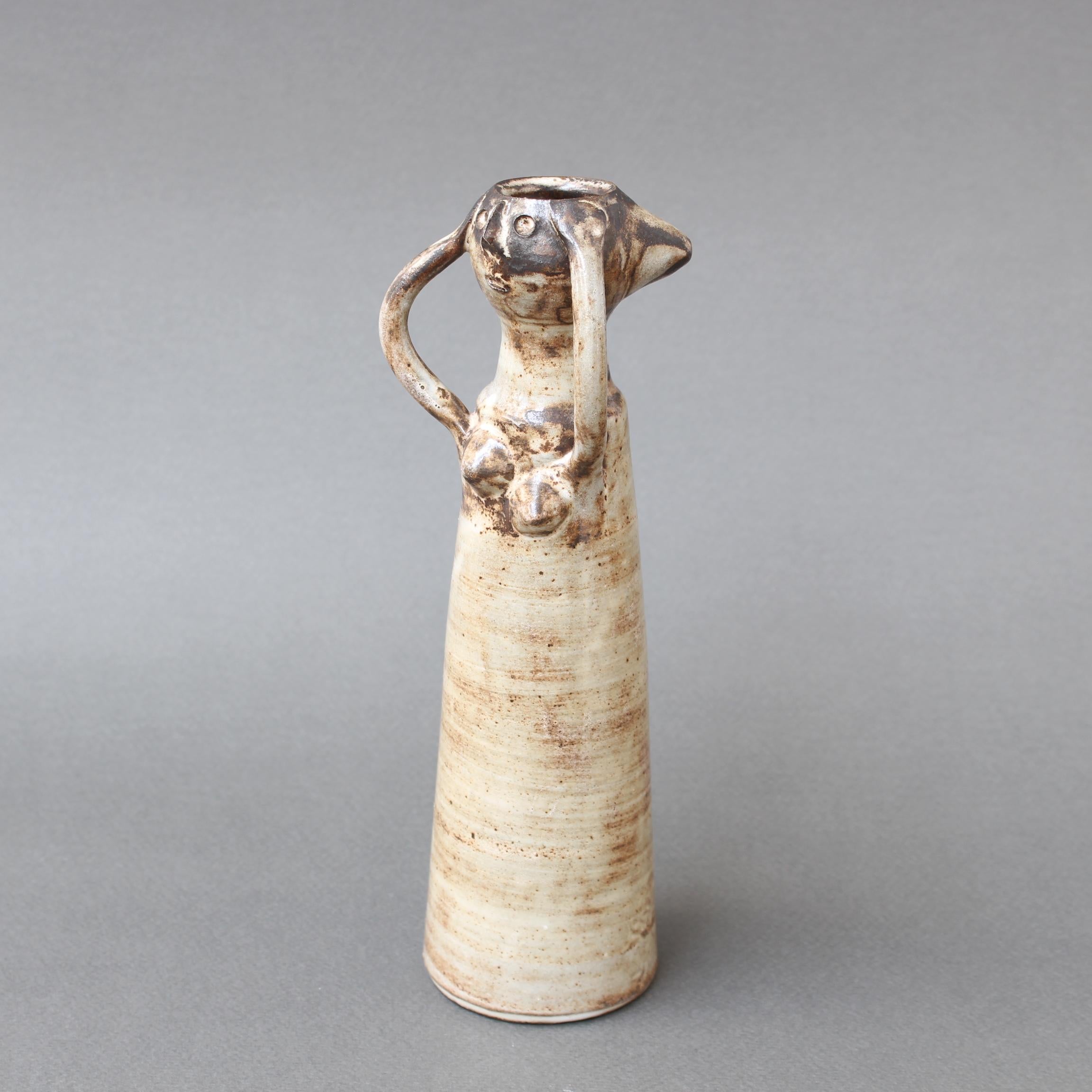 Glazed ceramic woman (circa 1960s) by Jacques Pouchain (1925-2005). This is a delightful, figurative art pottery vase modelled as a woman with her arms upraised and hands clutching the sides of her head. She has a conical wheel thrown body,