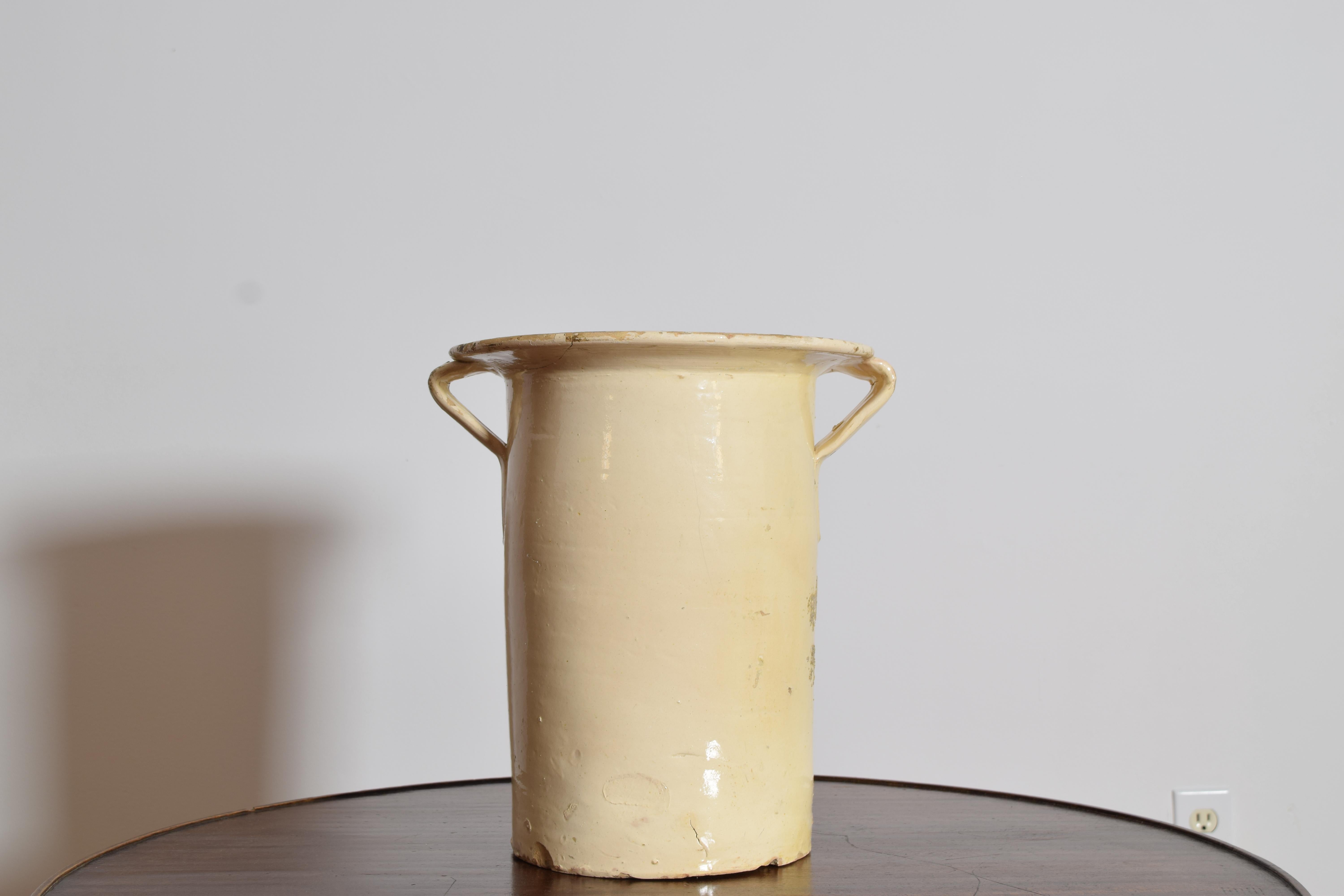 Pentola per confit francese alta e cilindrica in gres con manici ad anello applicati e uno spesso bordo arrotolato, XIX secolo. L'esterno è rifinito con una smaltatura morbida e pallida di tonalità avena con una fine craquelure su tutta la