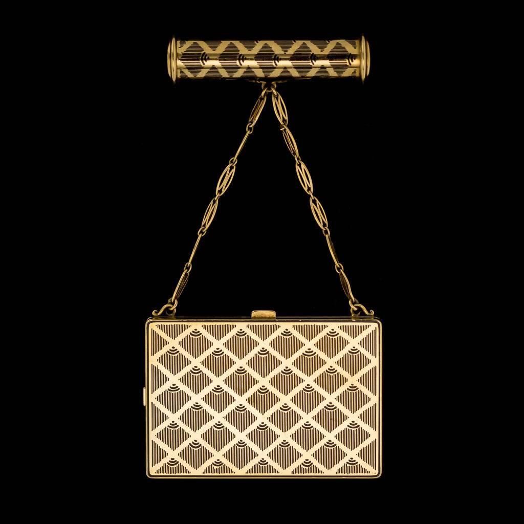 Antique early 20th century, French 18-karat gold and enamel compact with a suspended lipstick holder, of rectangular shape, decorated throughout with stylized art deco, geometrical design and filled with champleve enamel. Hallmarked French small