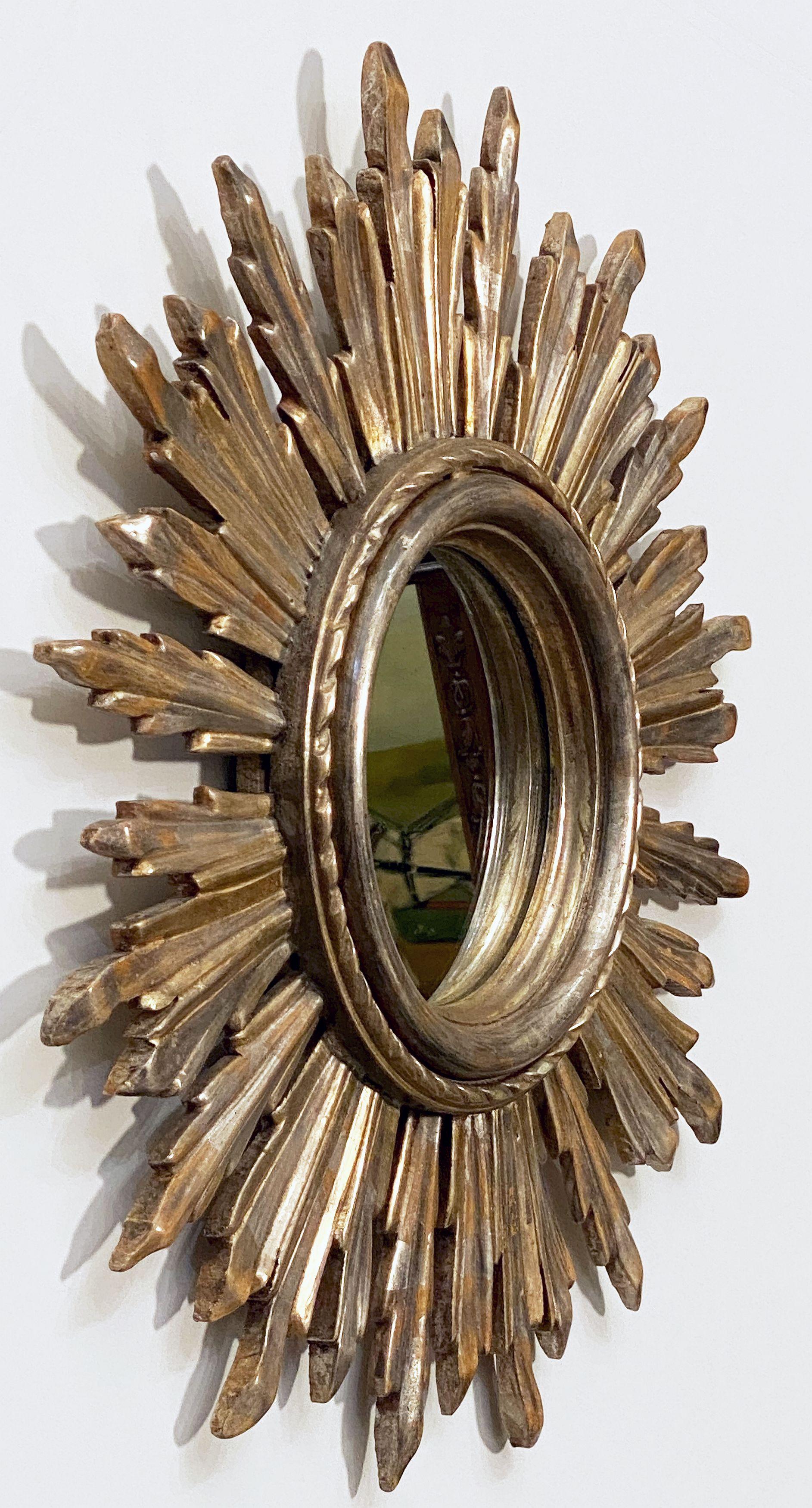 A lovely French gilt sunburst (or starburst) mirror featuring silver leaf and faded golden rays with round mirrored glass center in moulded frame.

Outside diameter is 21 inches

Diameter of interior mirror is 7 inches

