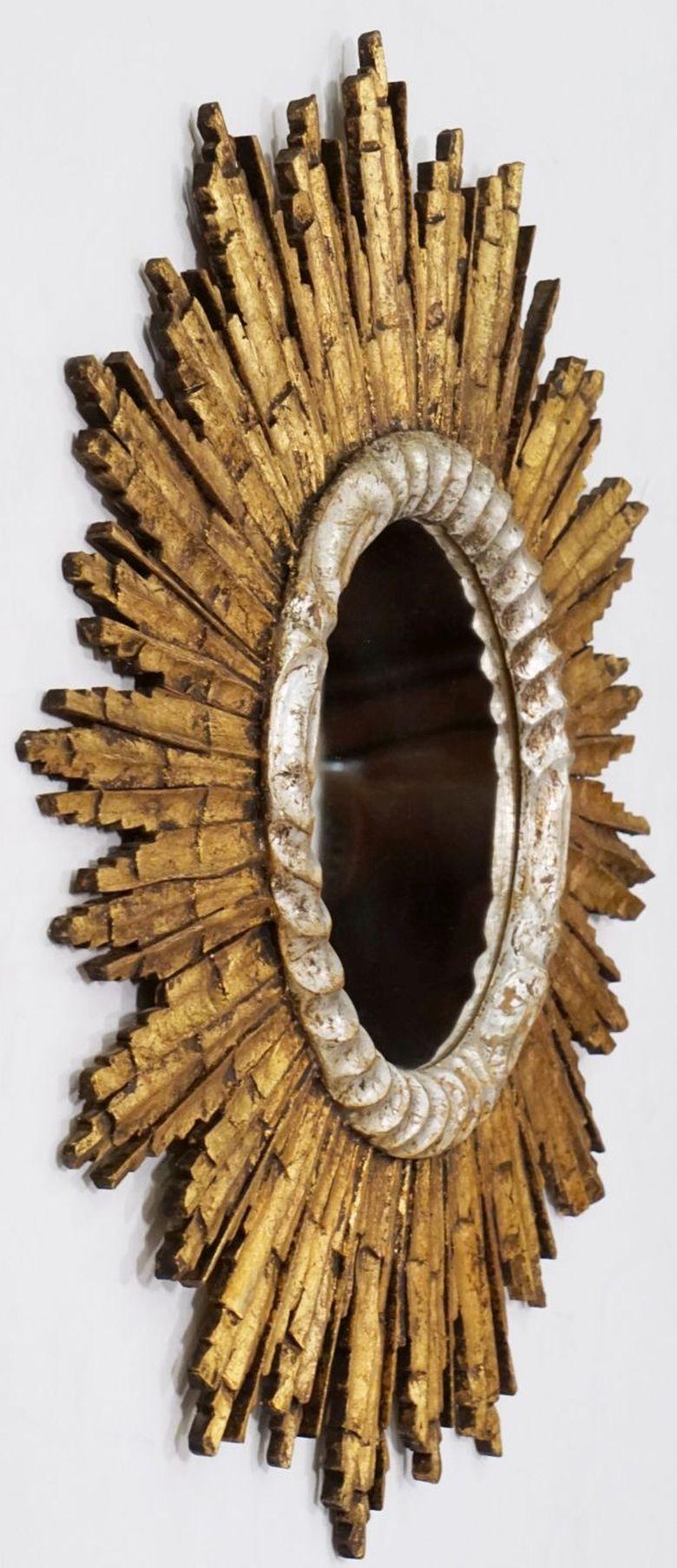 A lovely French gilt sunburst (or starburst) mirror, 25 inches diameter, with round mirrored glass center in a moulded silver-leaf and gold-leaf frame.