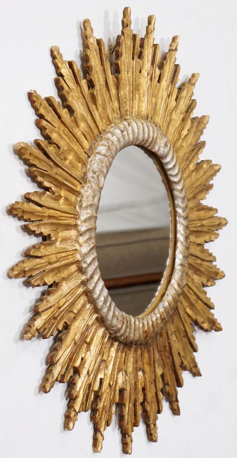 A lovely French gilt sunburst or starburst mirror, 27 1/2 inches diameter, with round mirrored glass center in a moulded silver-leaf and gold-leaf frame.