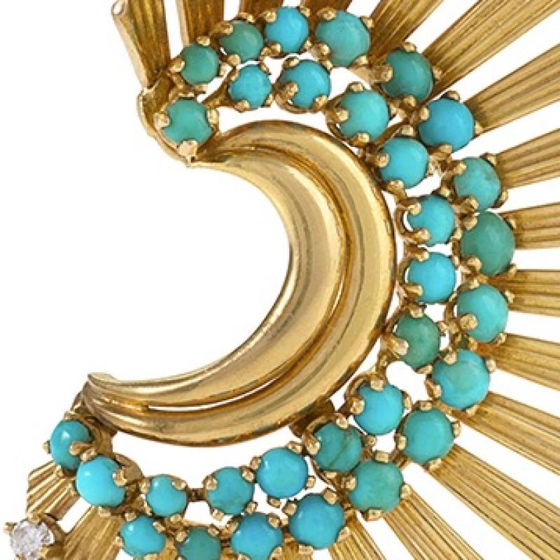 A French 18 karat gold brooch with turquoise, diamonds and rubies by Janca. The semicircular brooch radiates elegantly outward in a fan motif. Striations of textured gold and openwork are dotted with 12 rubies of approximate total weight of 1.2